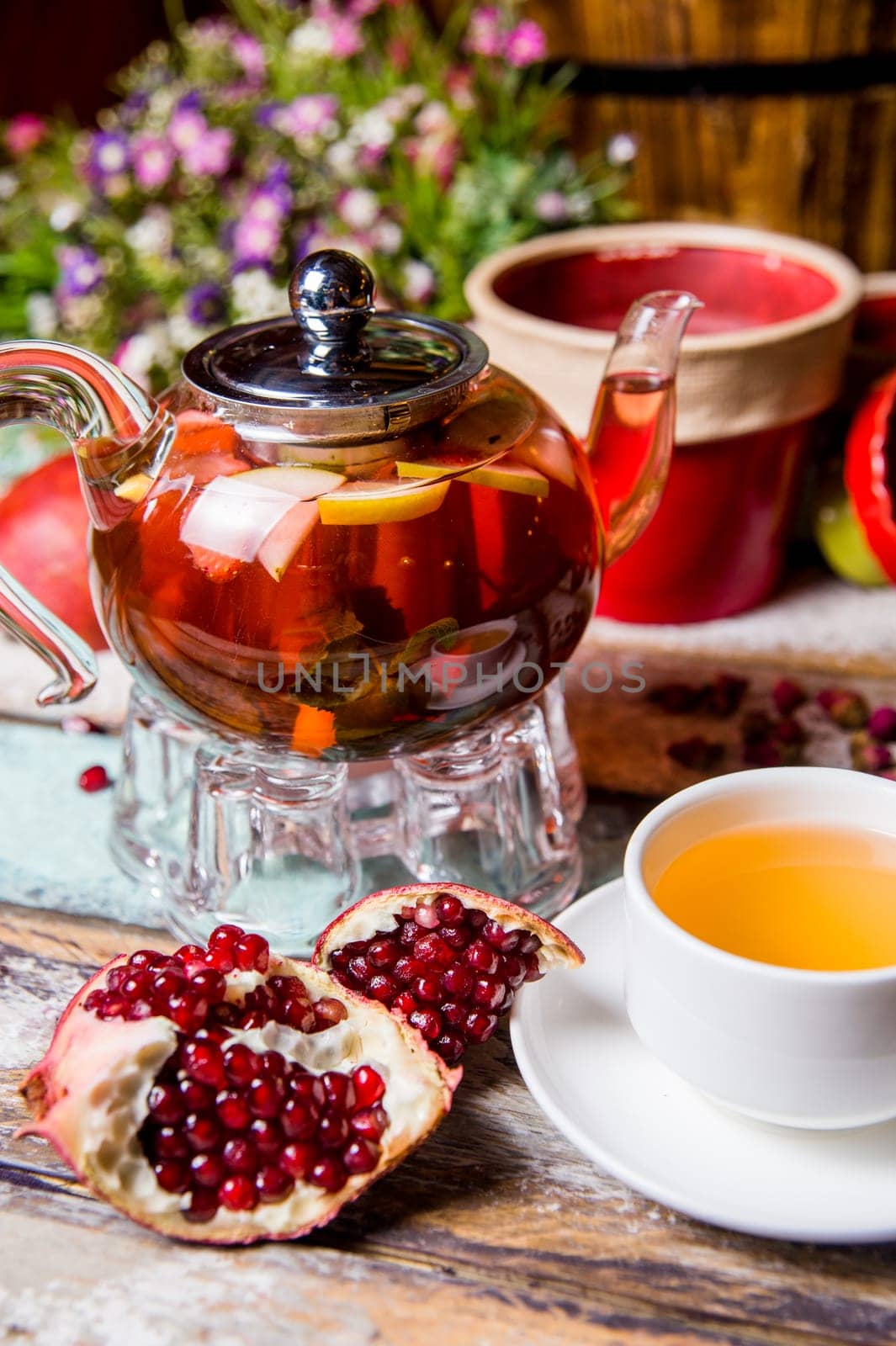 red fruit tea with pomegranate and white cup on the table by Pukhovskiy