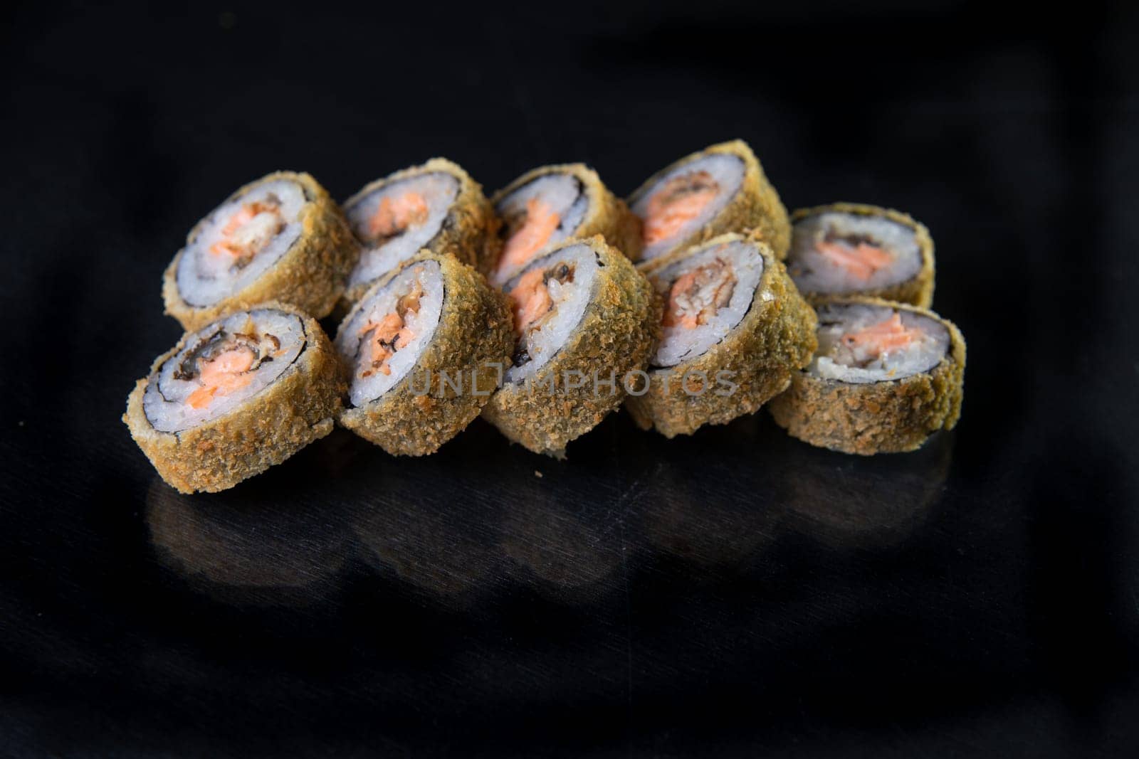 baked japanese rolls on a black background by Pukhovskiy