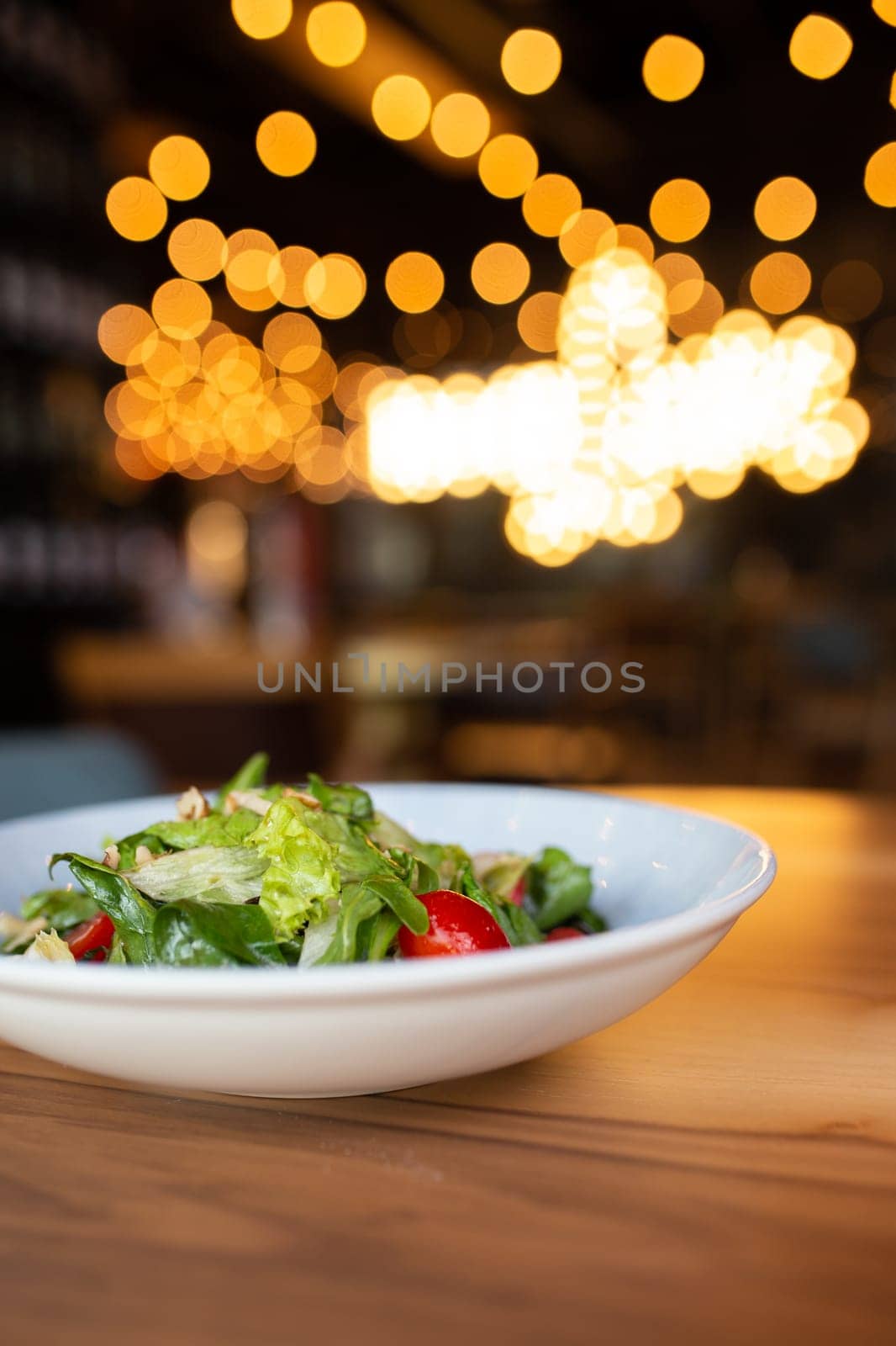 summer vegetable salad with herbs on the table in the restaurant by Pukhovskiy