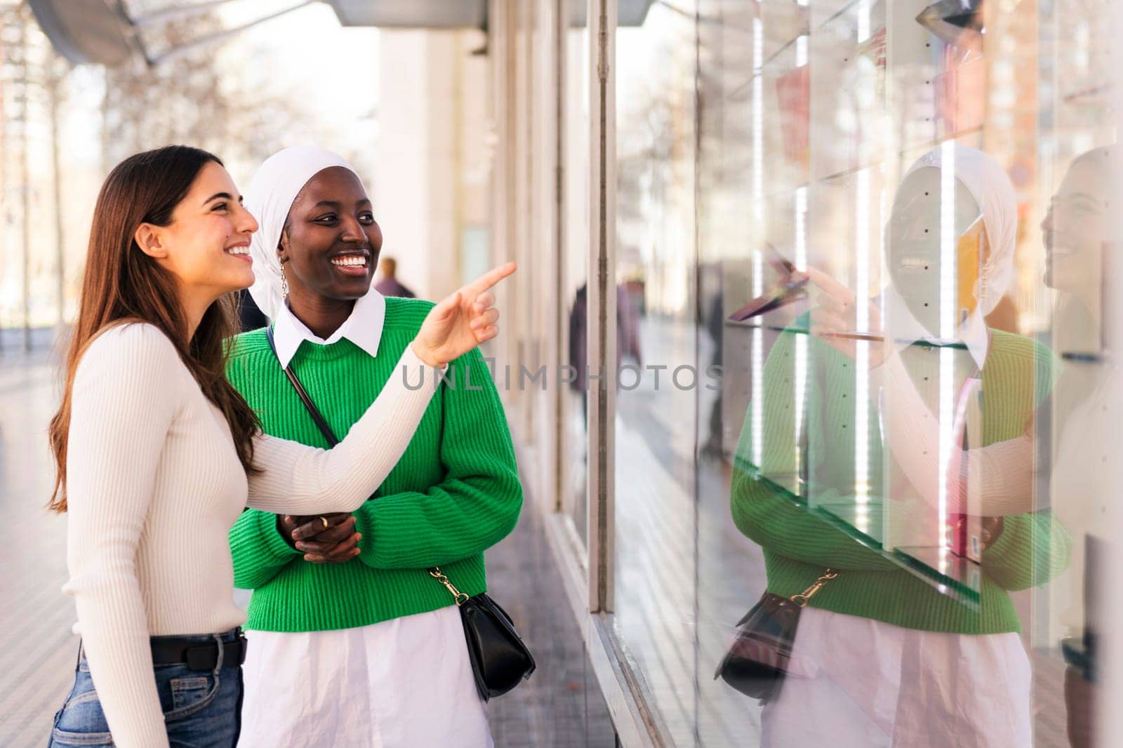 multiracial couple of friends smiling happy looking at a shop window, friendship and modern lifestyle concept, copy space for text
