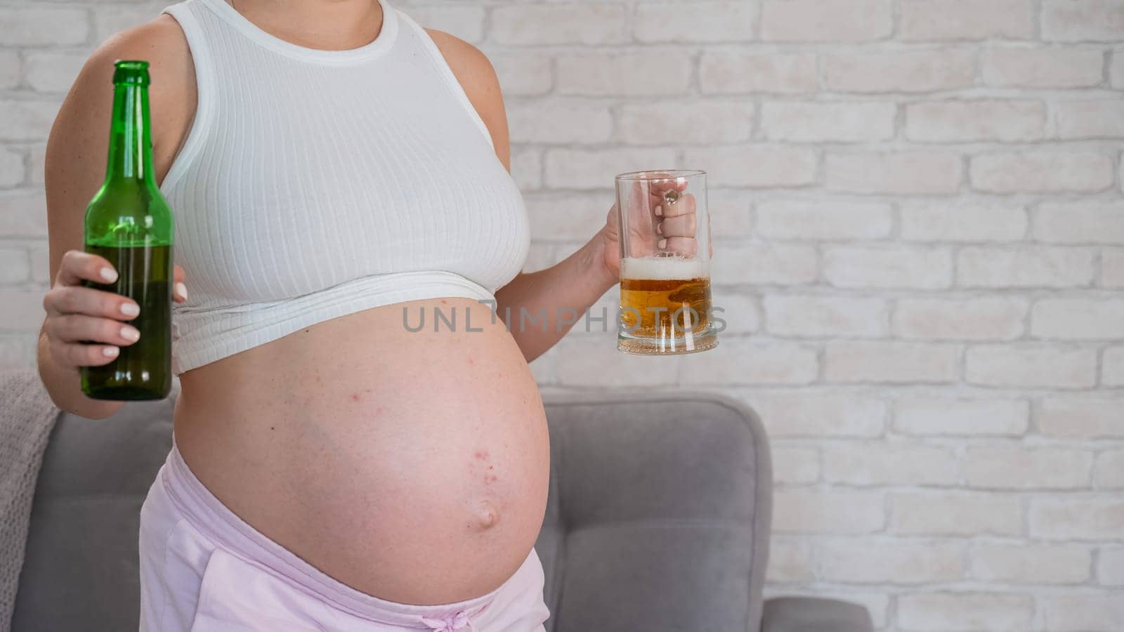 Pregnant woman holding glass and bottle of beer. by mrwed54