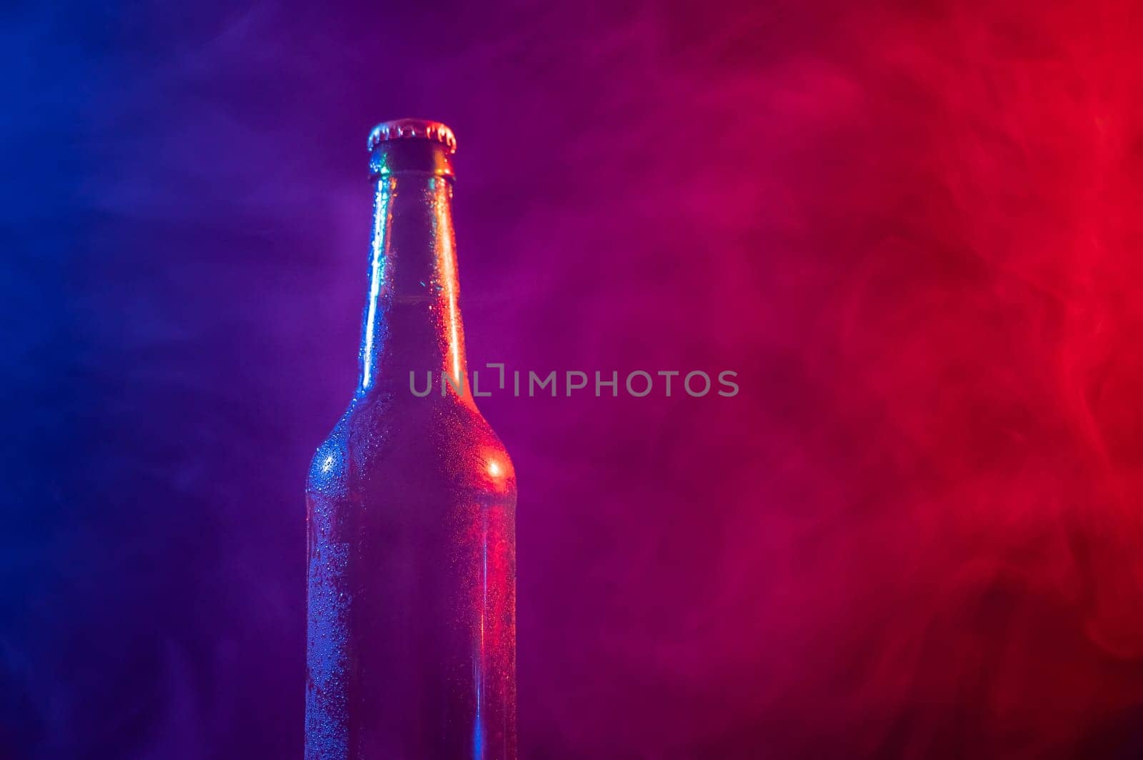 Glass bottle of beer in blue pink mist by mrwed54
