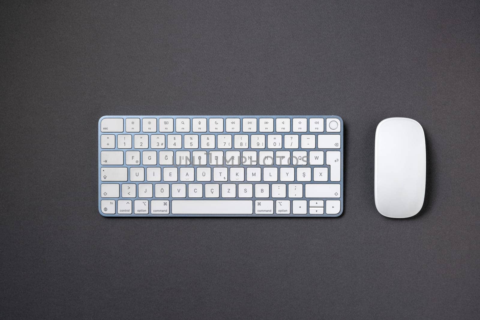 Top view of wireless keyboard and mouse on dark gray work desk by Sonat