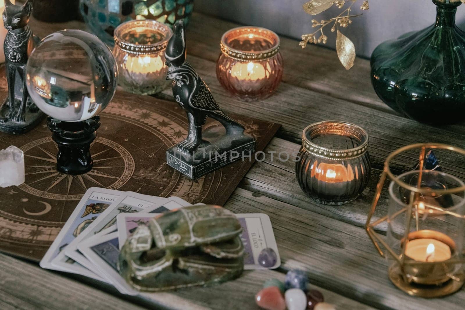 An atmospheric setting featuring a crystal ball, Egyptian cat statues, candles, and crystals, creating a mystical ambiance