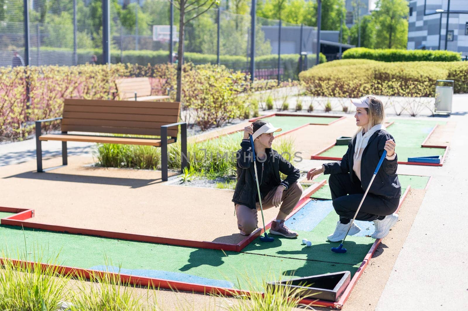 little girl and mother playing mini golf. High quality photo