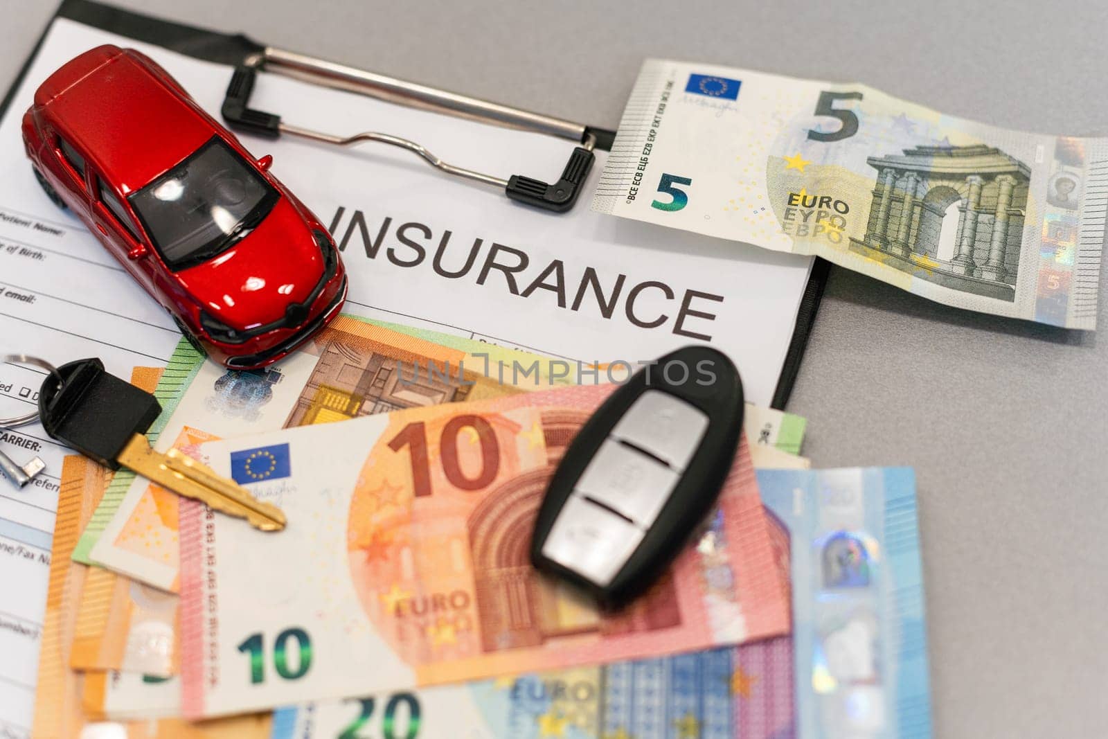 Top view of car insurance claim form with car key and car toy on desk. High quality photo