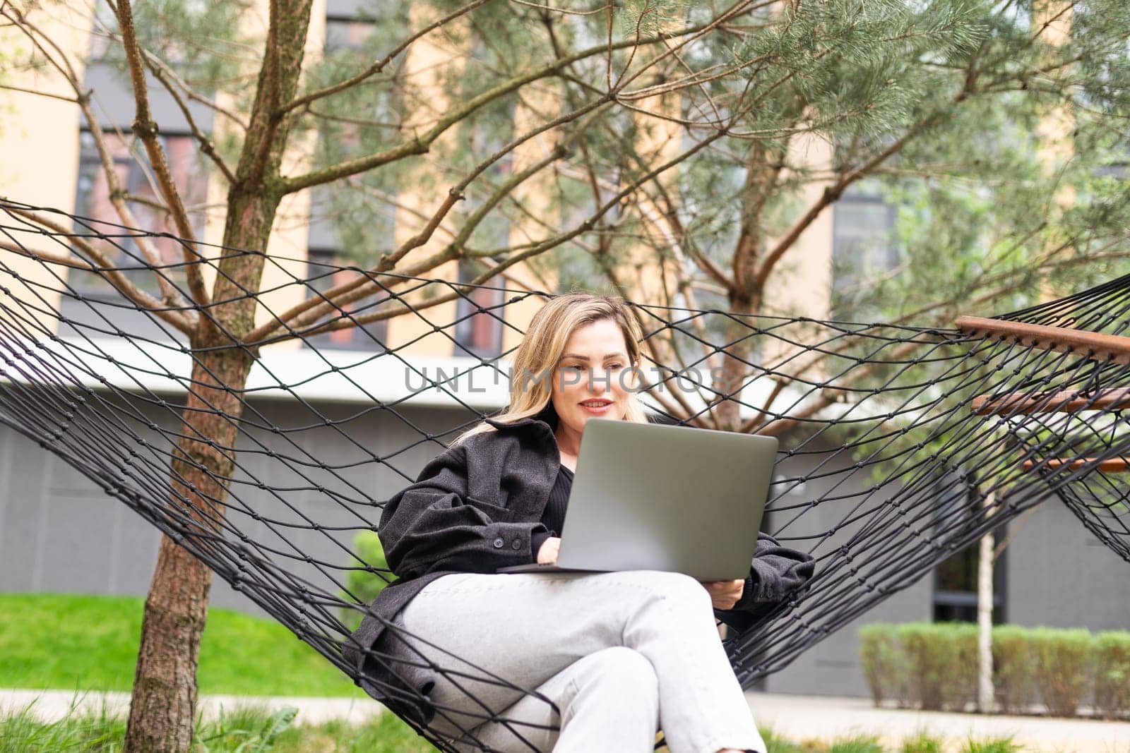 Young woman with laptop outside. High quality photo