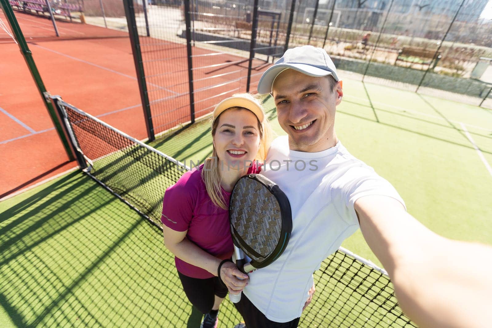 Paddle tennis woman and man team posing in wide angle image by Andelov13