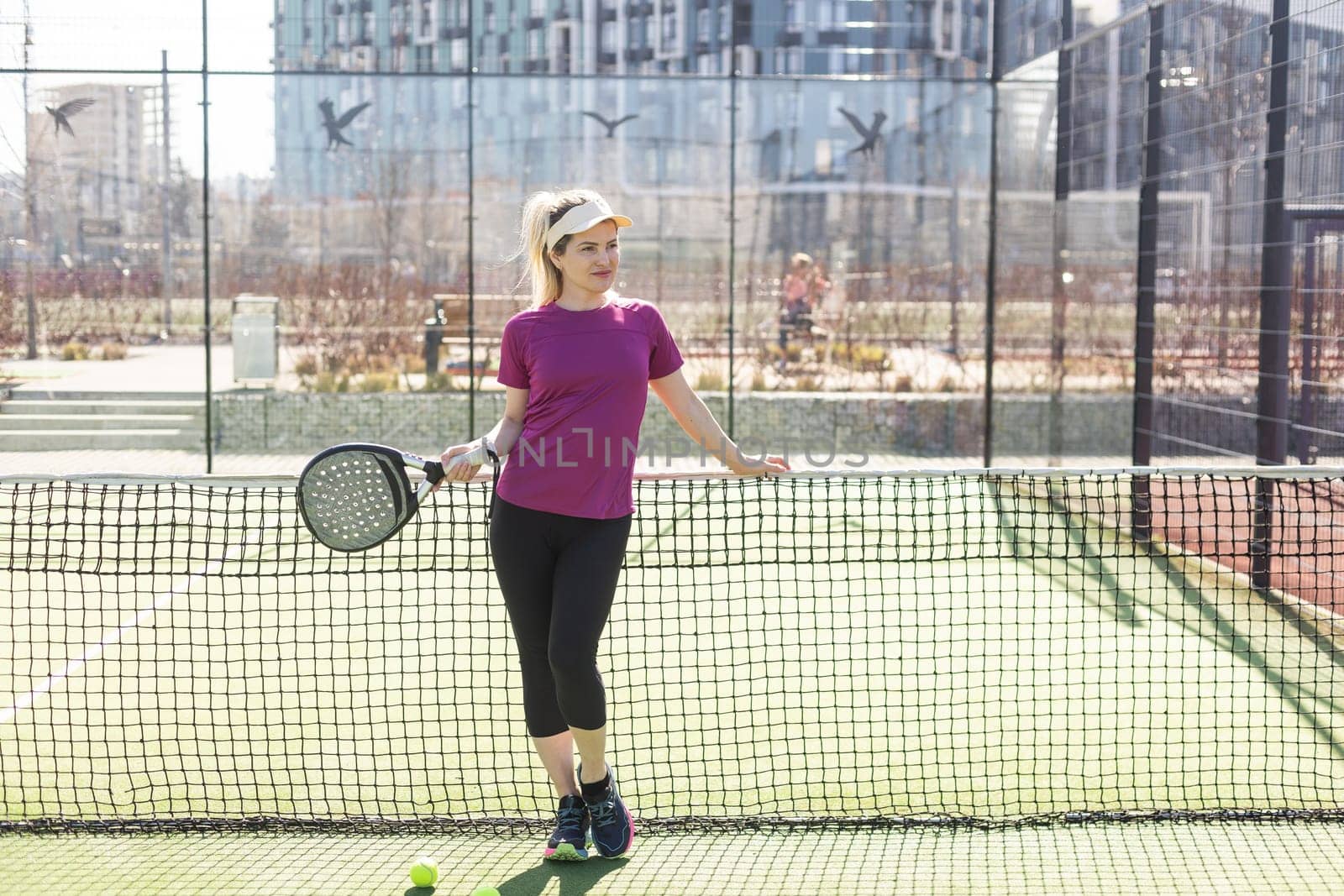 Active young woman trying to beat the ball by Padel racket while playing tennis in the court by Andelov13