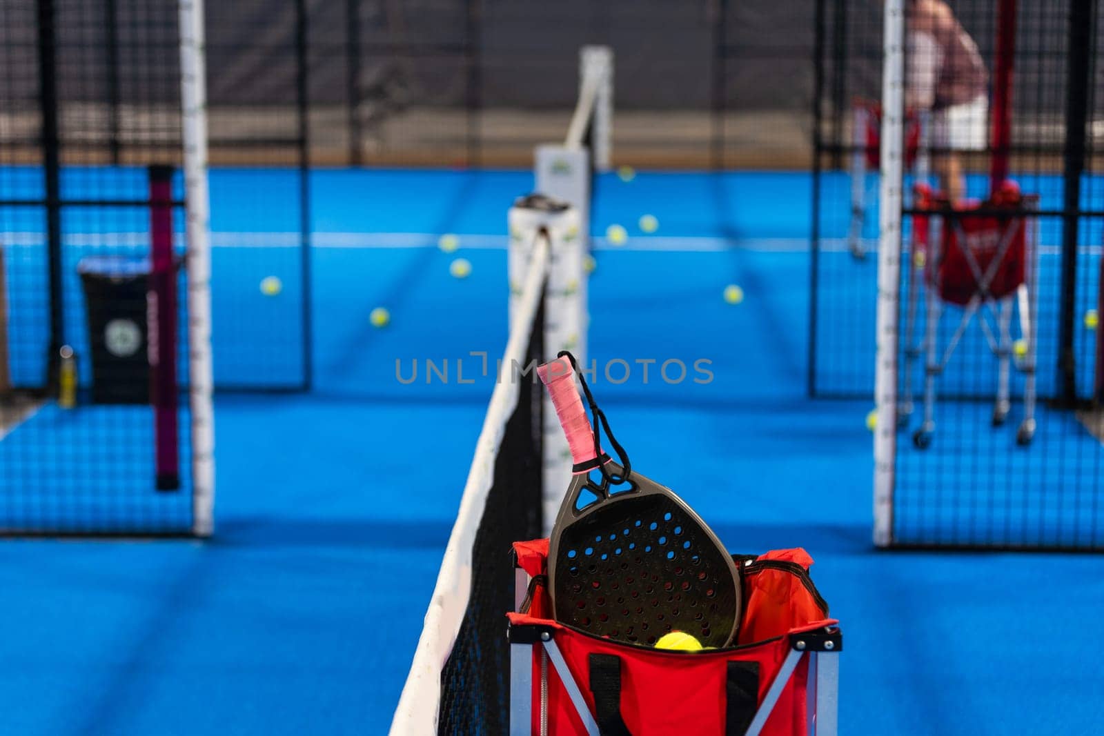 balls near the net of a blue padel tennis court by Andelov13