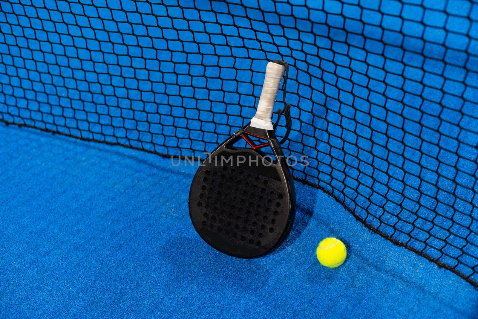 paddle tennis racket and balls on the blue paddle court by Andelov13