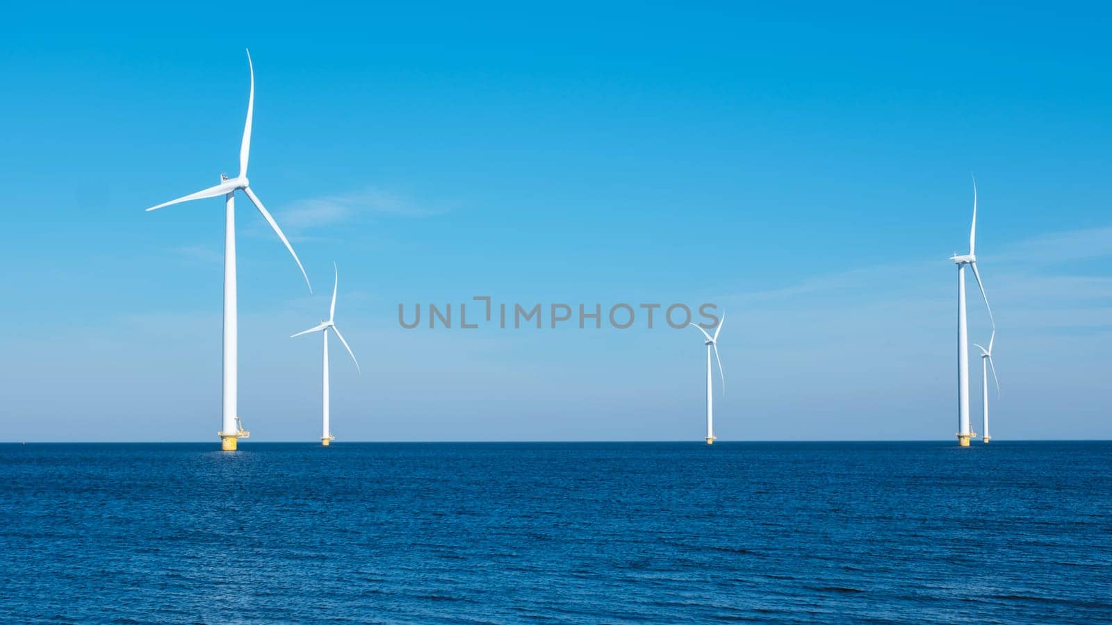 A majestic row of wind turbines rises from the ocean in the Netherlands Flevoland, harnessing the power of the wind to generate clean energy. Windmill turbines at sea green energy transition in Europe