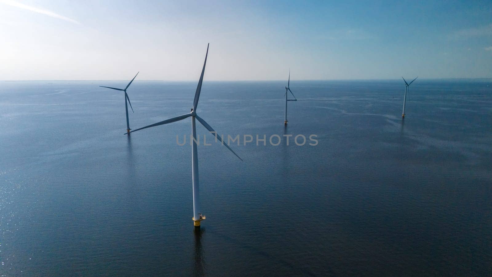 A group of wind turbines stand tall, floating gracefully in the ocean, harnessing the power of the wind to generate clean energy by fokkebok