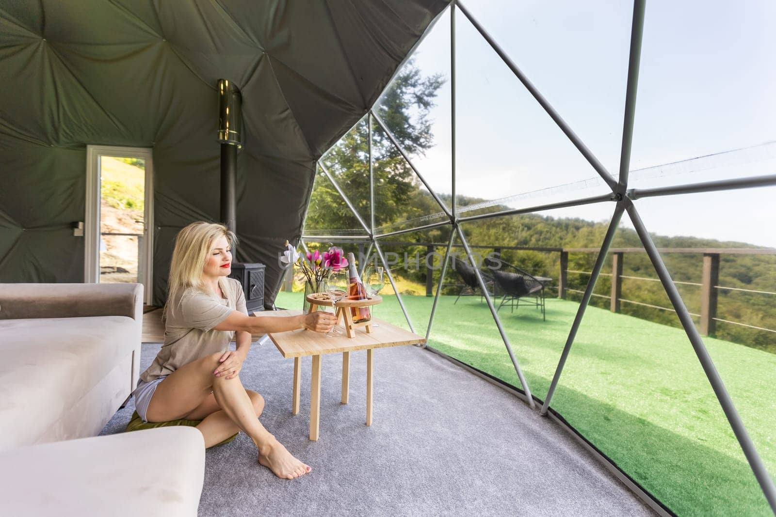 Transparent bubble tent at glamping, Lush forest around and interior. woman resting in glamping.