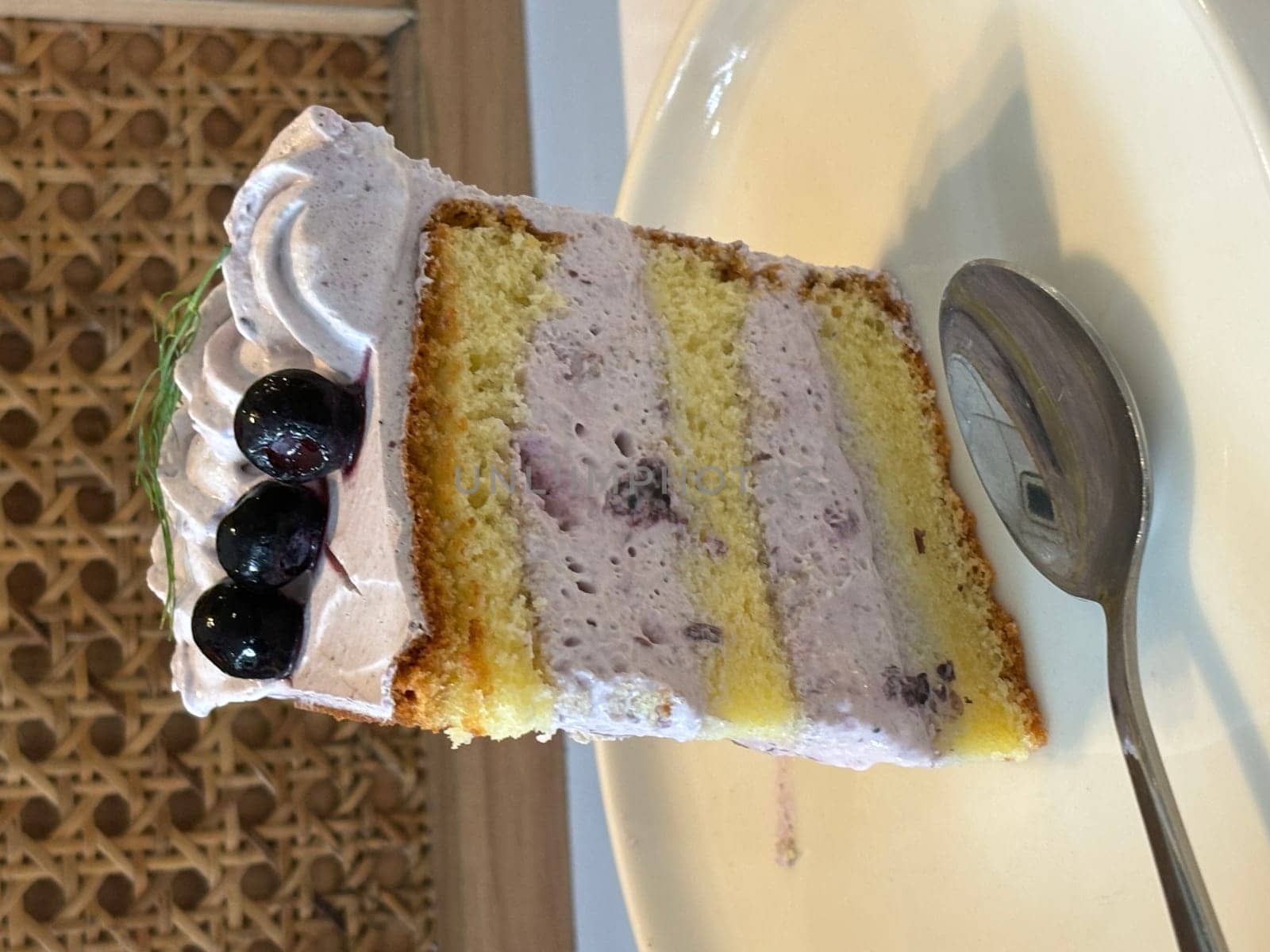 slice of blueberry cake decorated with fresh berries on white plate, delicious layered cake, top view by antoksena