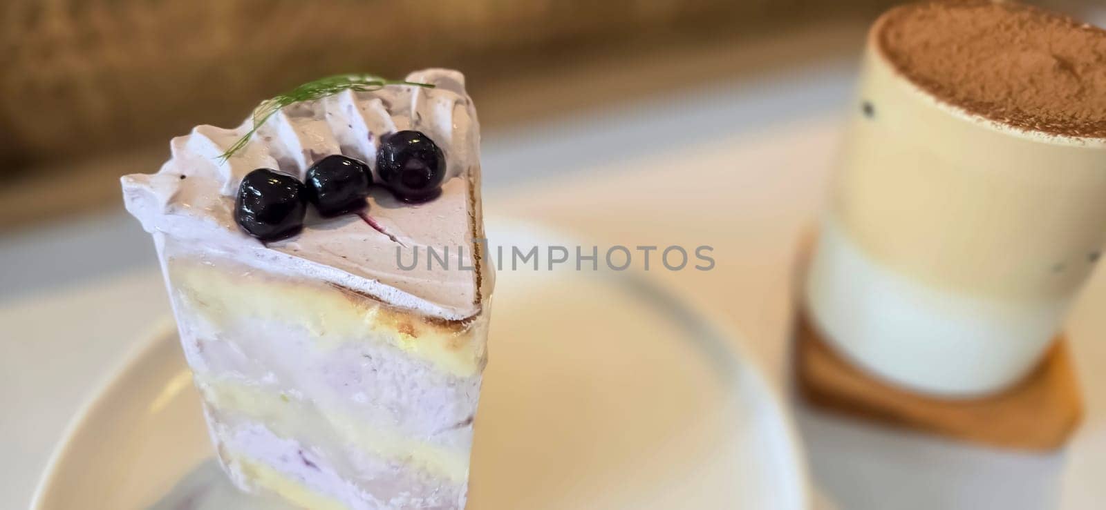 slice of blueberry cake decorated with fresh berries on white plate, delicious layered cake, top view in the cafe