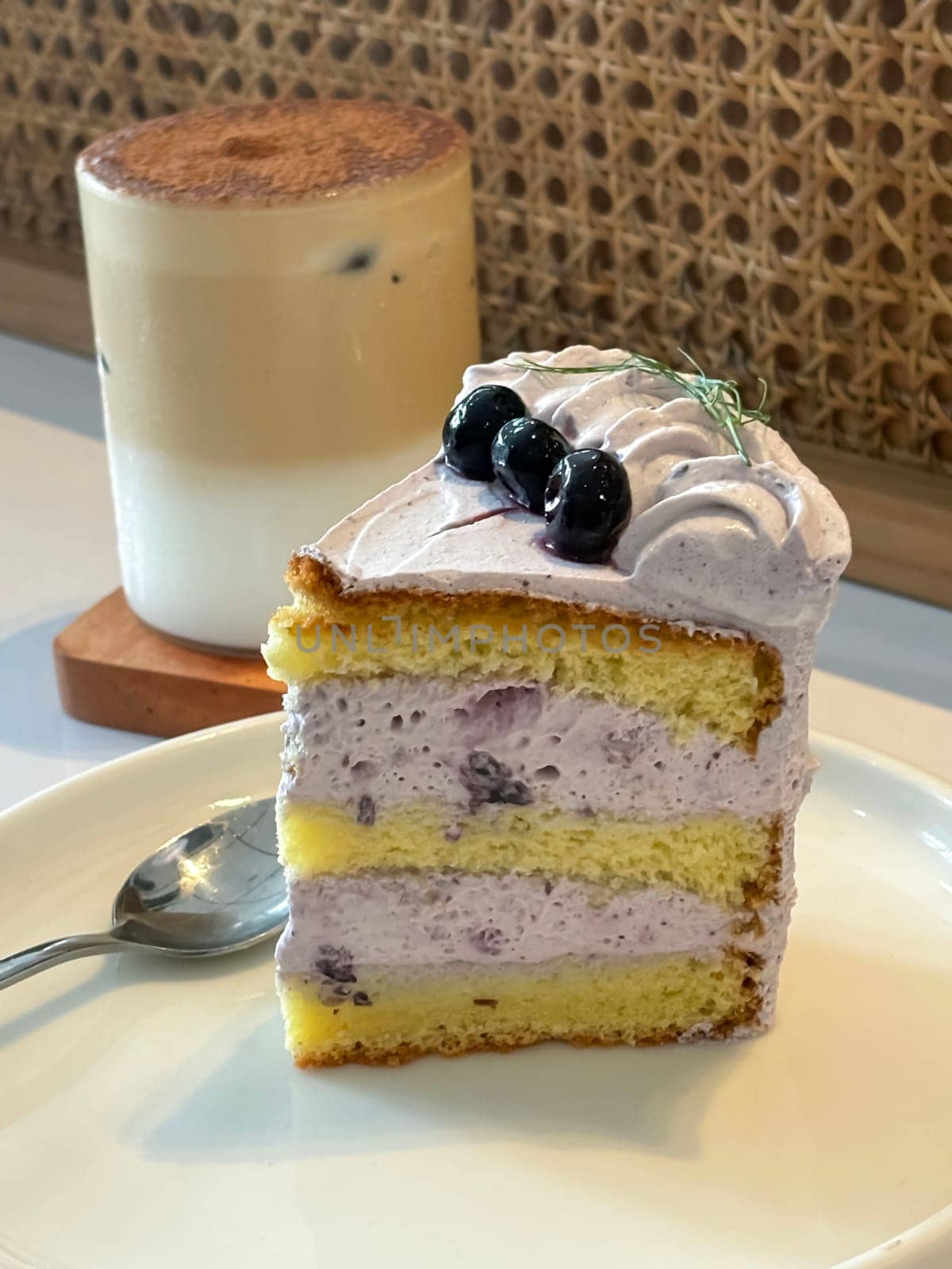 slice of blueberry cake decorated with fresh berries on white plate, delicious layered cake, top view by antoksena