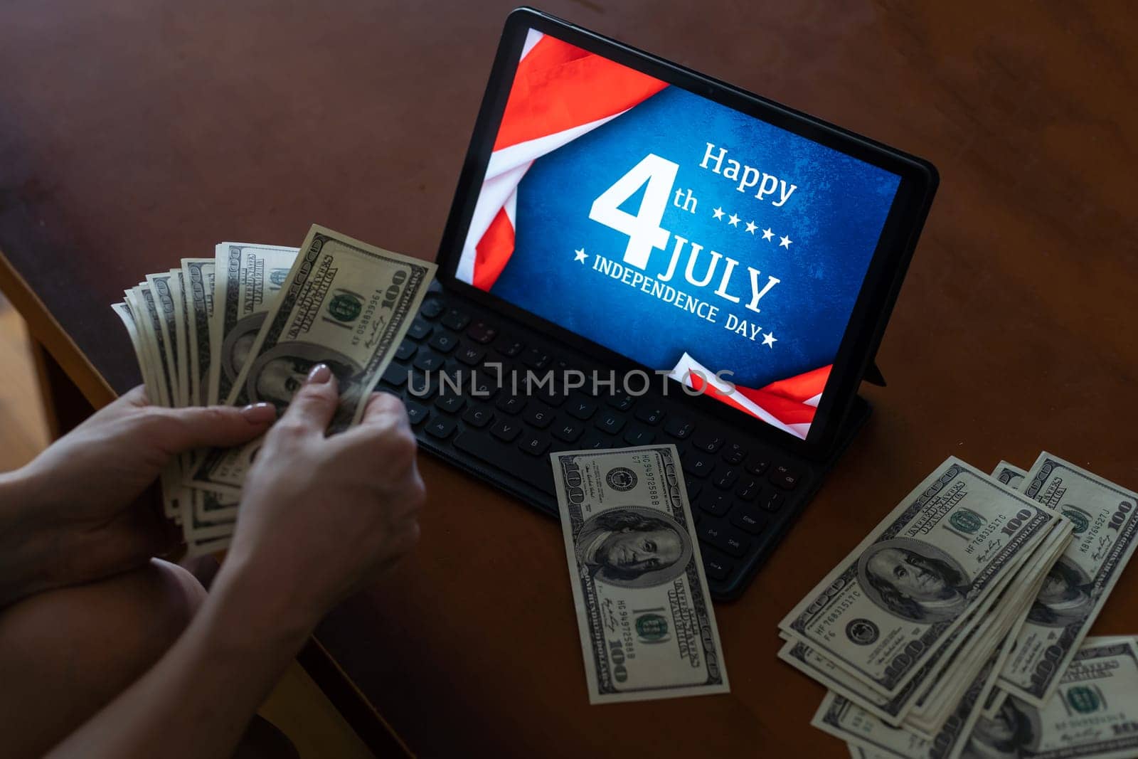 woman holding dollar money and usa flag on tablet.
