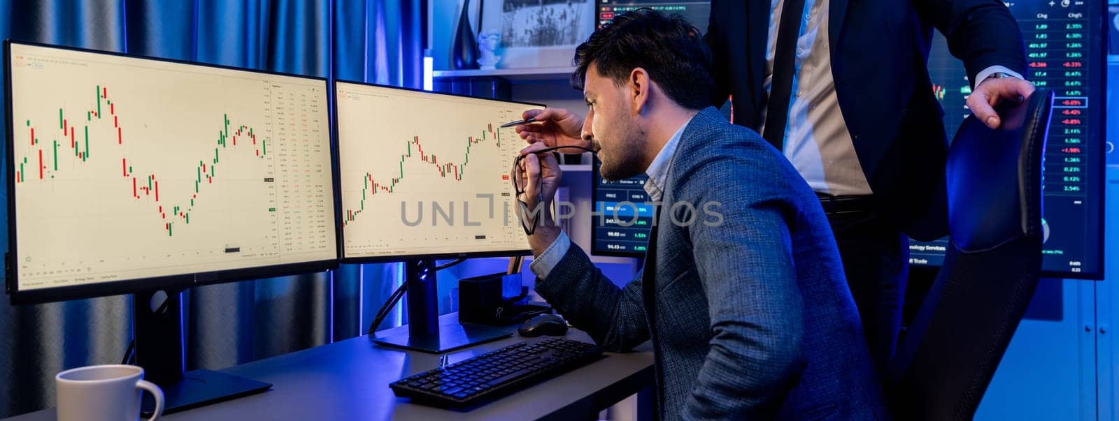 Stock exchange traders looking on high profit chart investment in panorama view, analyzing on monitor at night. Concept of discussing financial technology growth in neon light at workplace. Sellable.