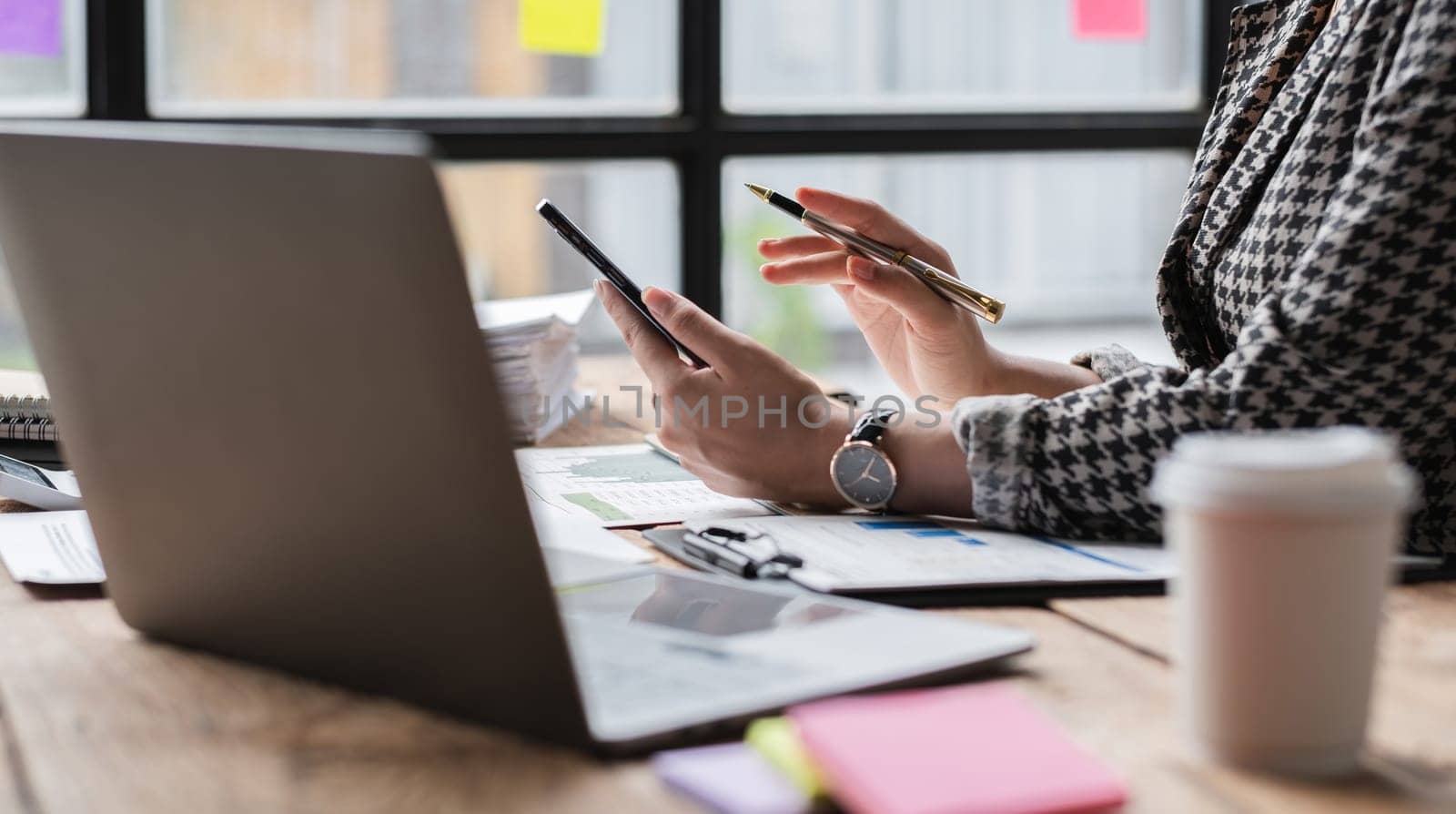 Close-up view of Asian businesswoman working online and planning financial calculation data working from home. Businesswoman and business planner concept by wichayada