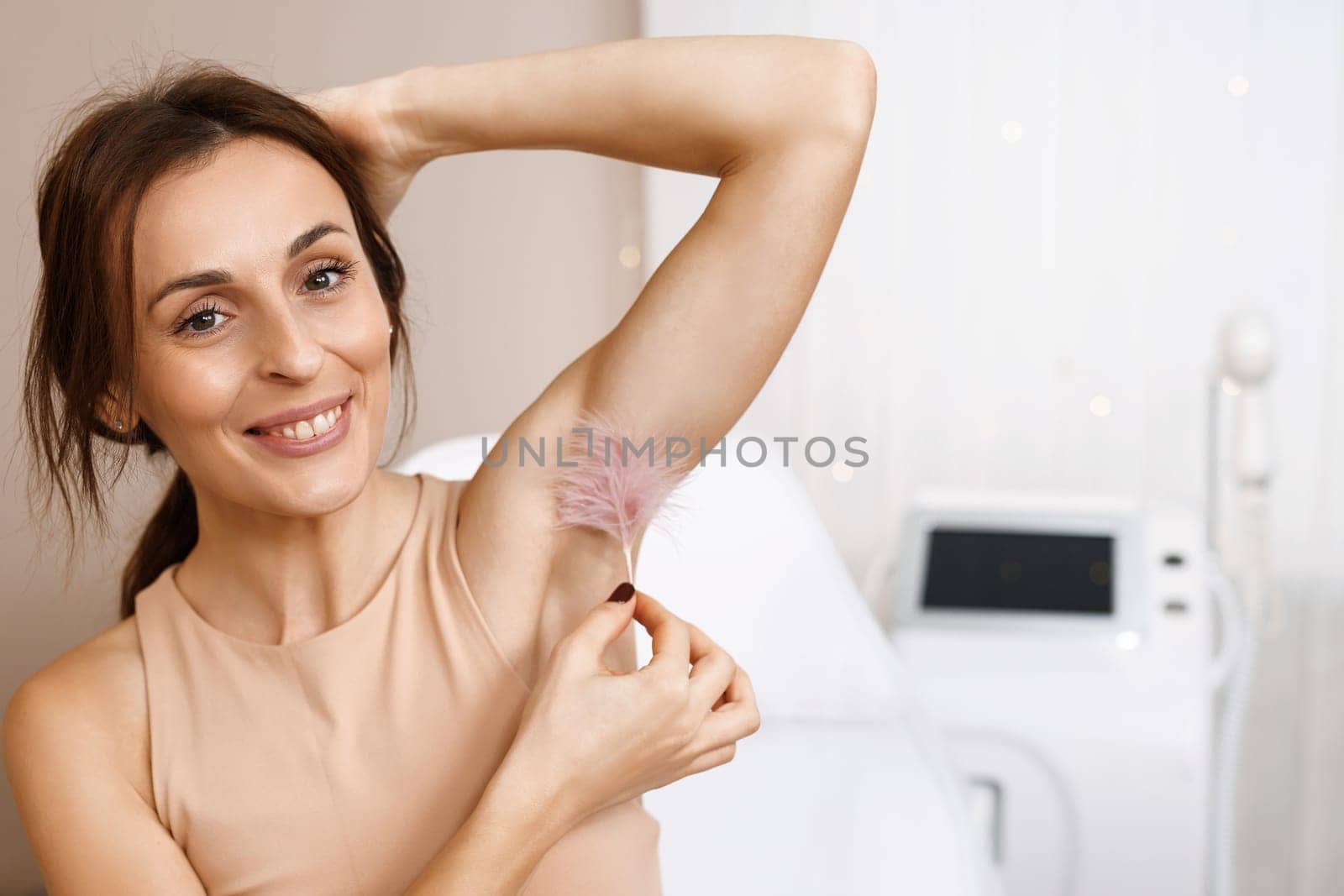 Portrait of beauty. Armpit care. Large white feather near the skin. Epilation of armpits. Concept after shaving with laser depilation.