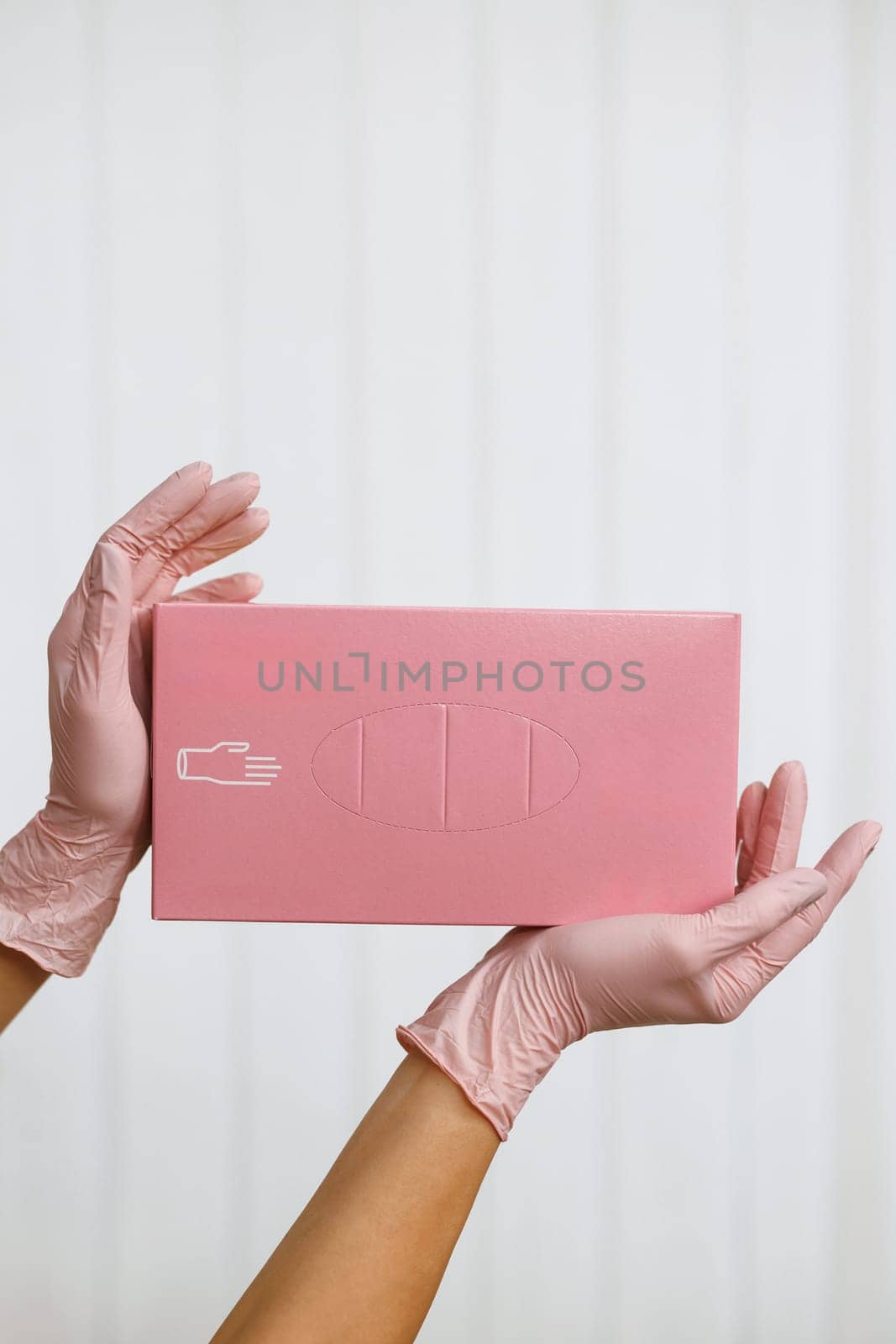 Hands of a woman holding a box with gloves. Box of new medical gloves isolated on white. Cleanliness and sterility in work concept by uflypro