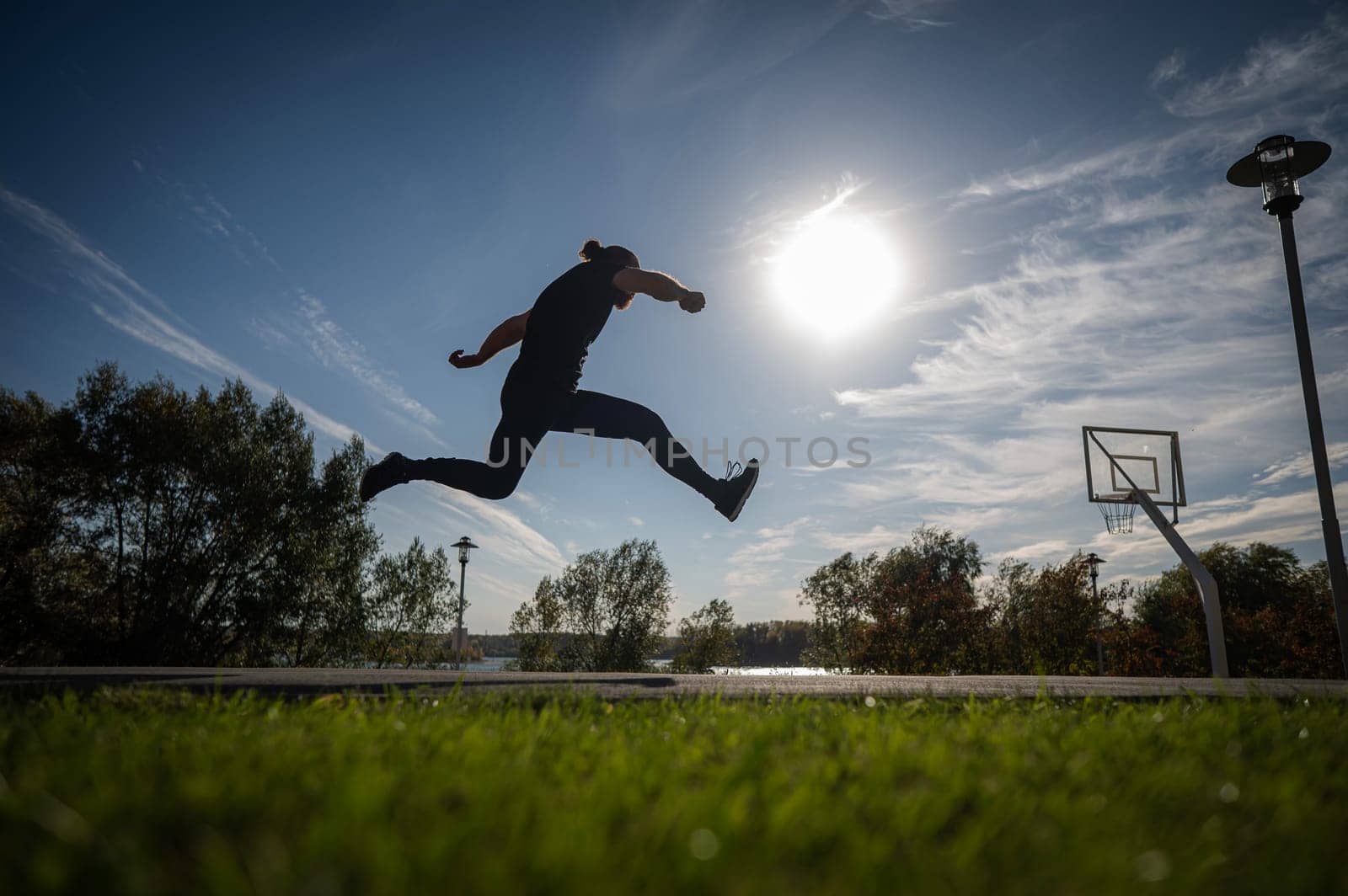 Caucasian man jumping with high hip raise outdoors. by mrwed54