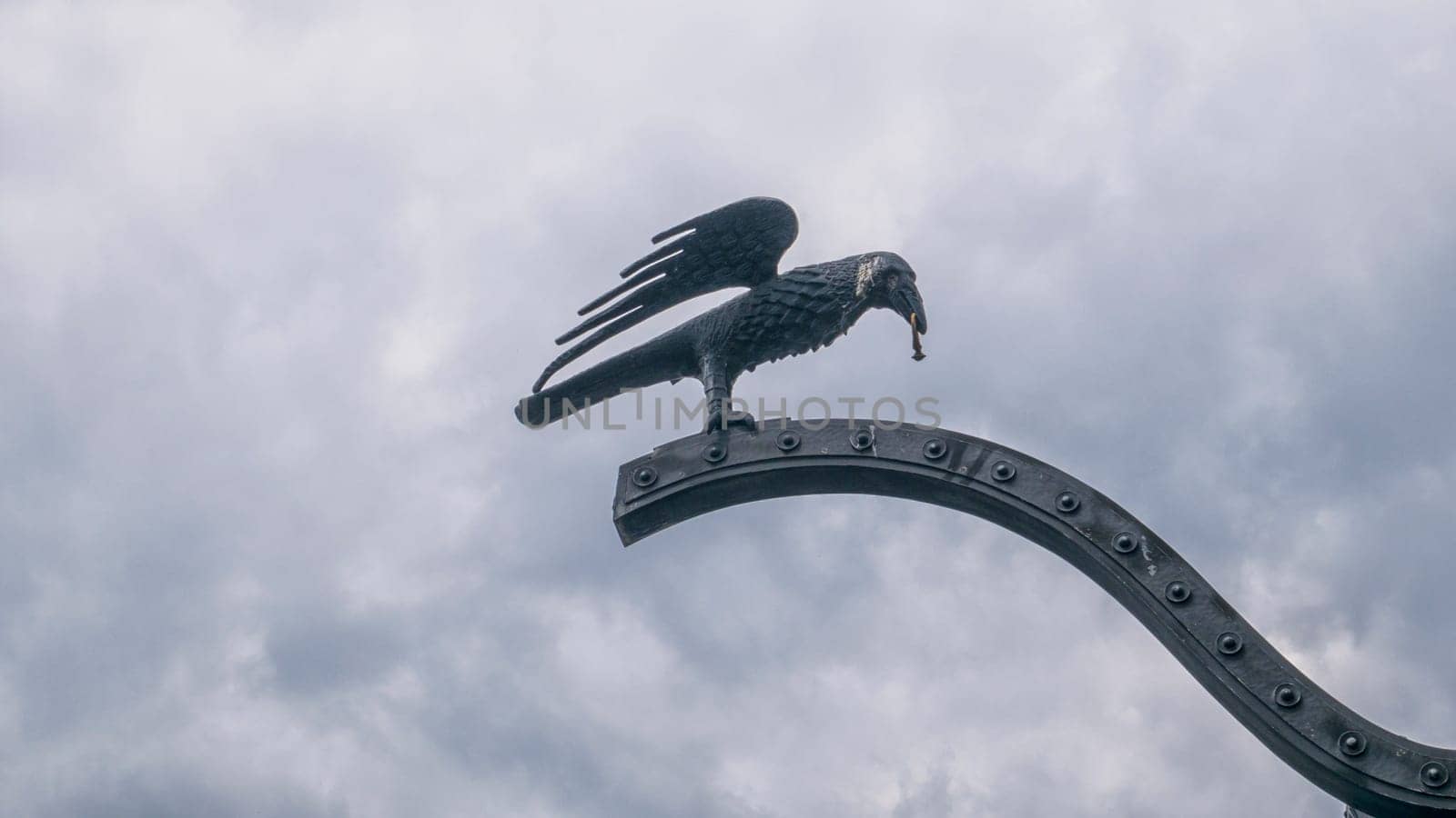 BUDAPEST/HUNGARY - 2023-05-06: Raven with a ring in its beak at the Buda castle gate Budapest, Hungary