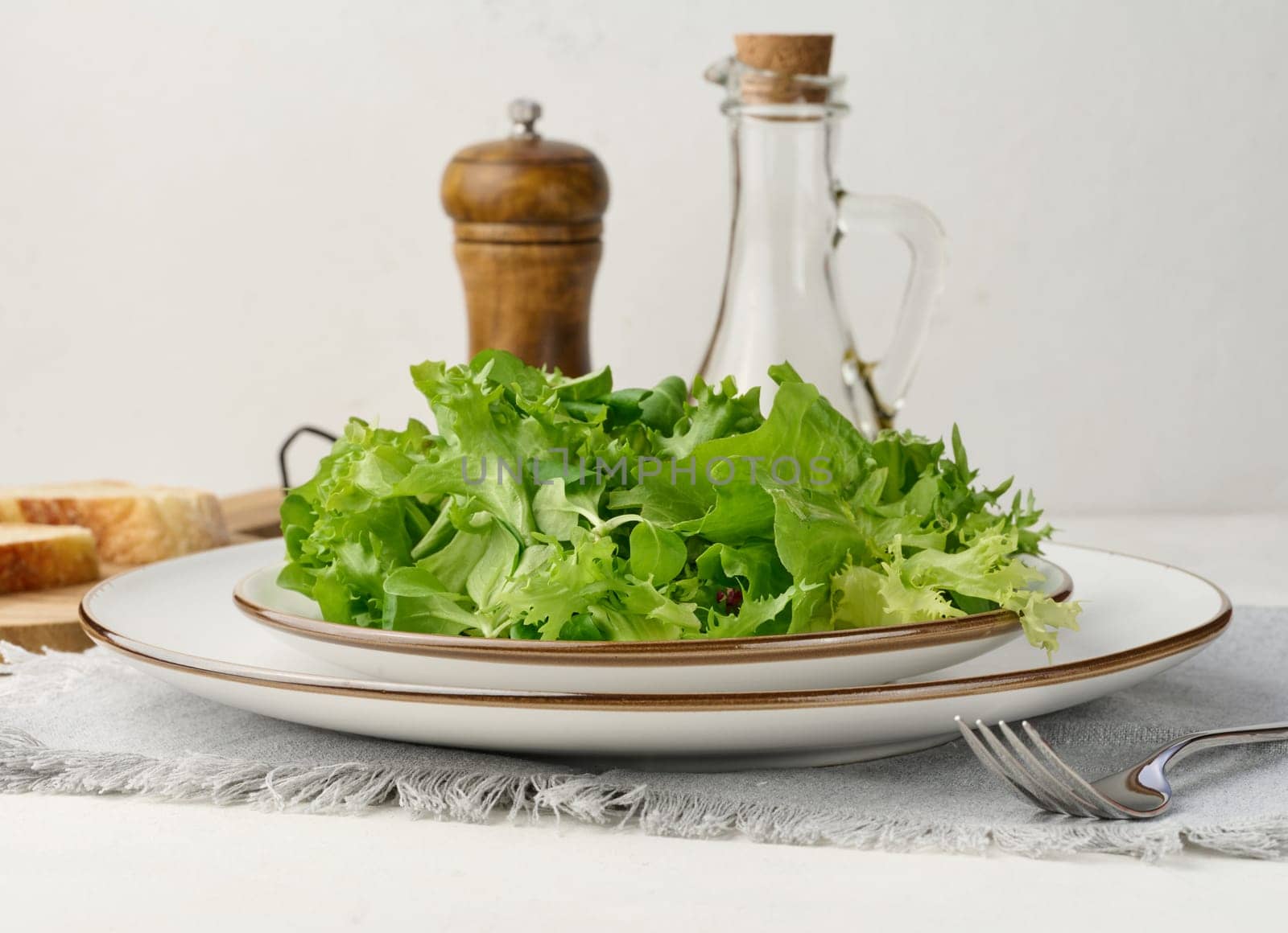 Fresh green lettuce leaves in a white plate on the table, healthy food by ndanko