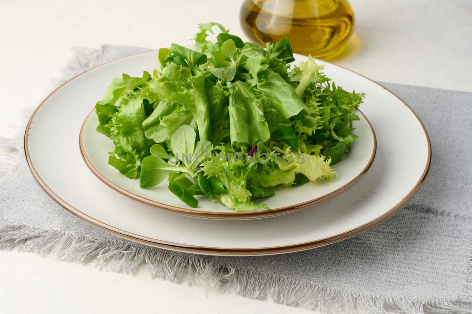 Fresh green lettuce leaves in a white plate on the table, healthy food