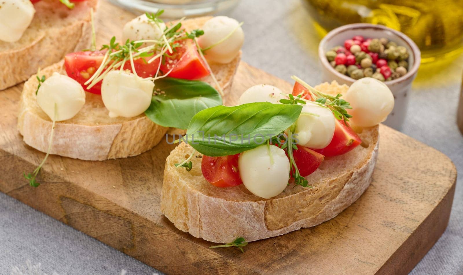 Round mozzarella, cherry tomatoes and microgreens on a piece of white bread, a healthy sandwich by ndanko