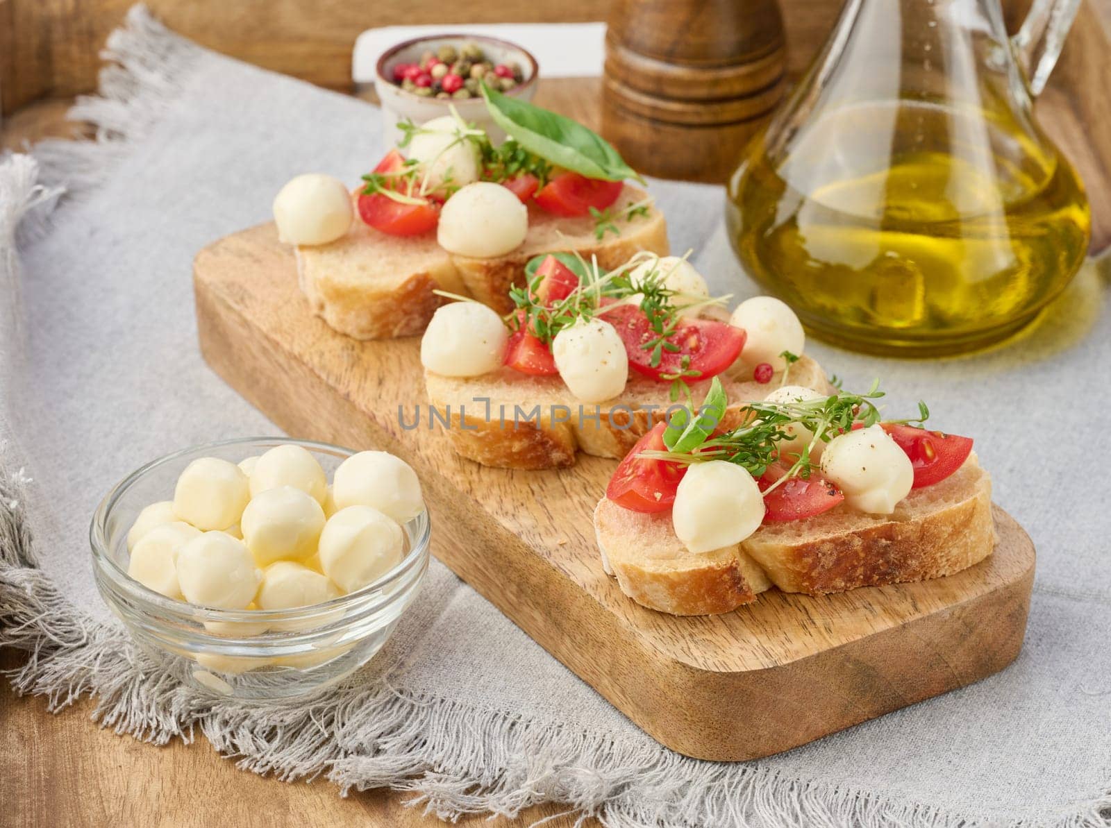 Round mozzarella, cherry tomatoes and microgreens on a piece of white bread, a healthy sandwich by ndanko