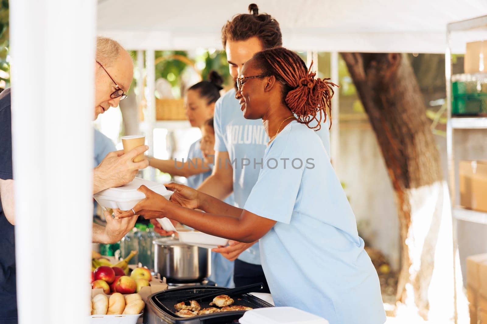 Multiracial hunger relief team provides free meals and assistance at local center, supporting the needy and homeless. Volunteers distribute non-perishable food, sharing compassion and hope.