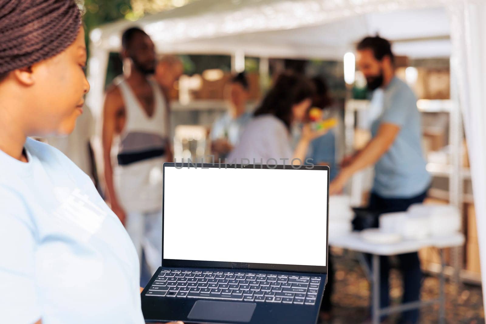 Volunteer holds laptop with white screen by DCStudio