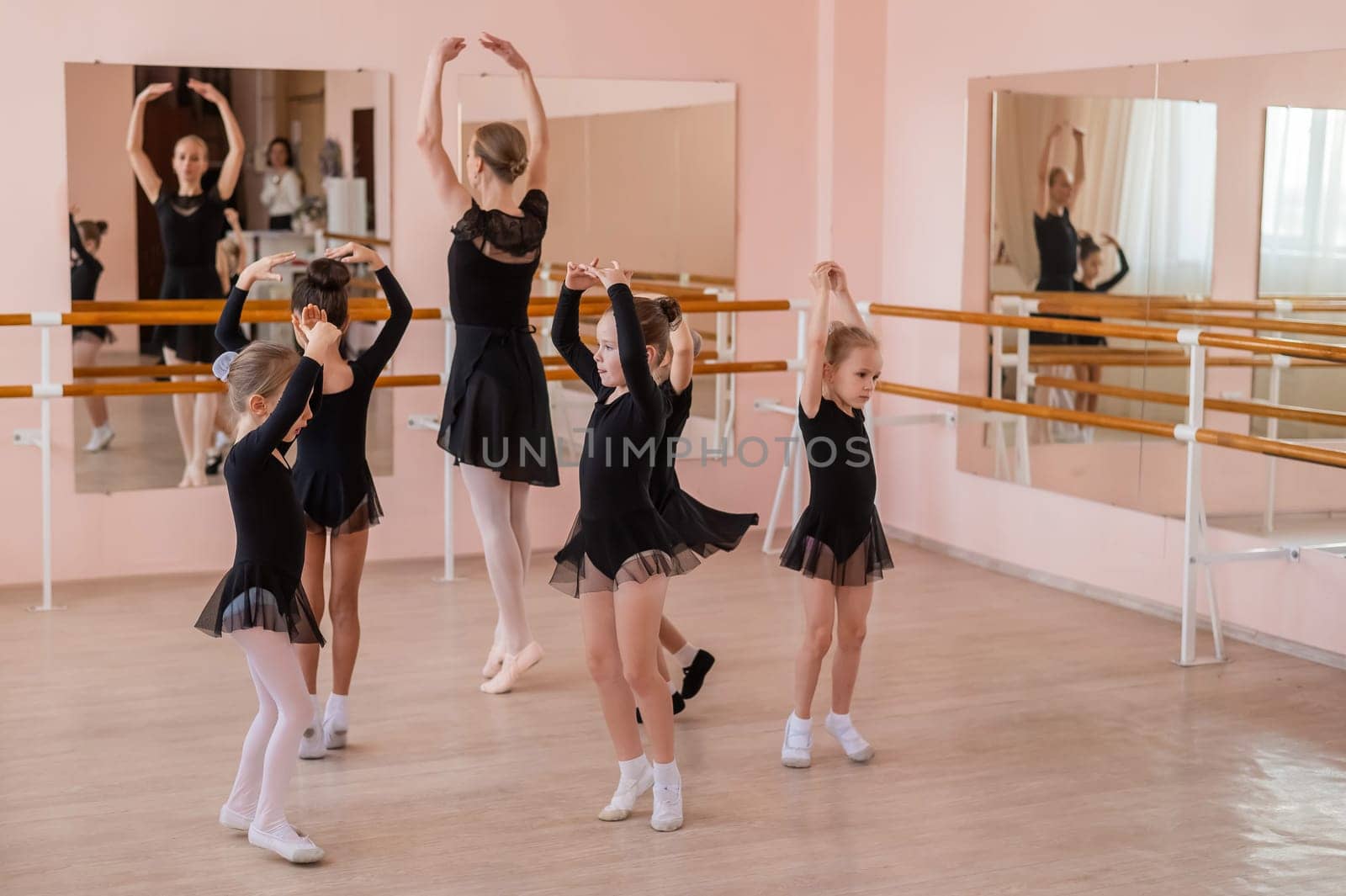 Children's ballet school. Caucasian woman teaching ballet to little girls. by mrwed54