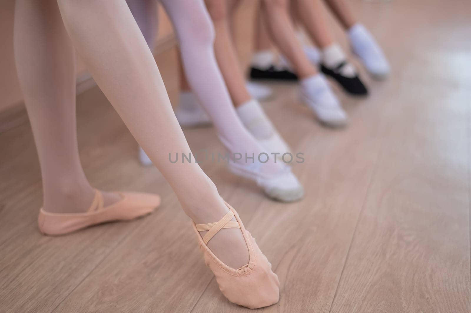 Close-up of feet of 5 little girls and teacher at ballet class. by mrwed54