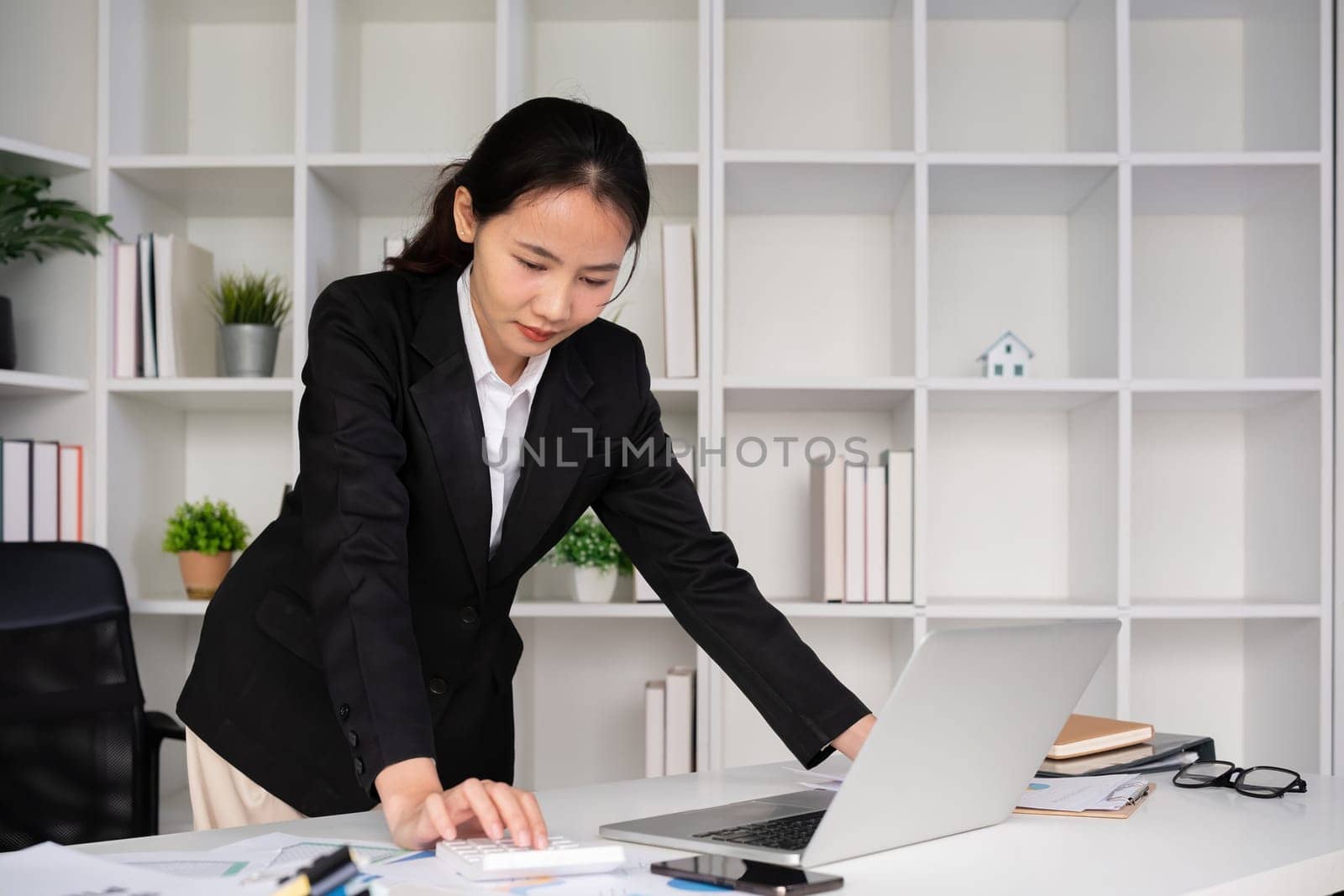 Young Asian businesswoman in the office is disappointed and stressed about her performance in the company. by wichayada