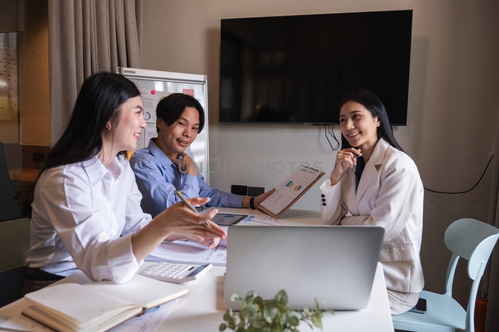 Group of Asian businessmen discuss to plan analysis of company marketing strategy and brainstorm with report documents in office. by wichayada