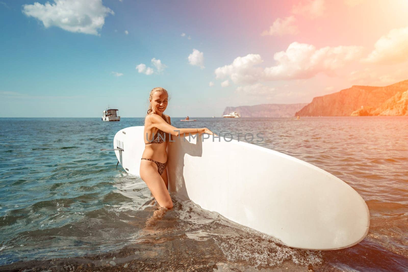Woman sup sea travel in black bikini. Portrait of a happy girl on the background of a surfboard in the sea on a sunny summer day.