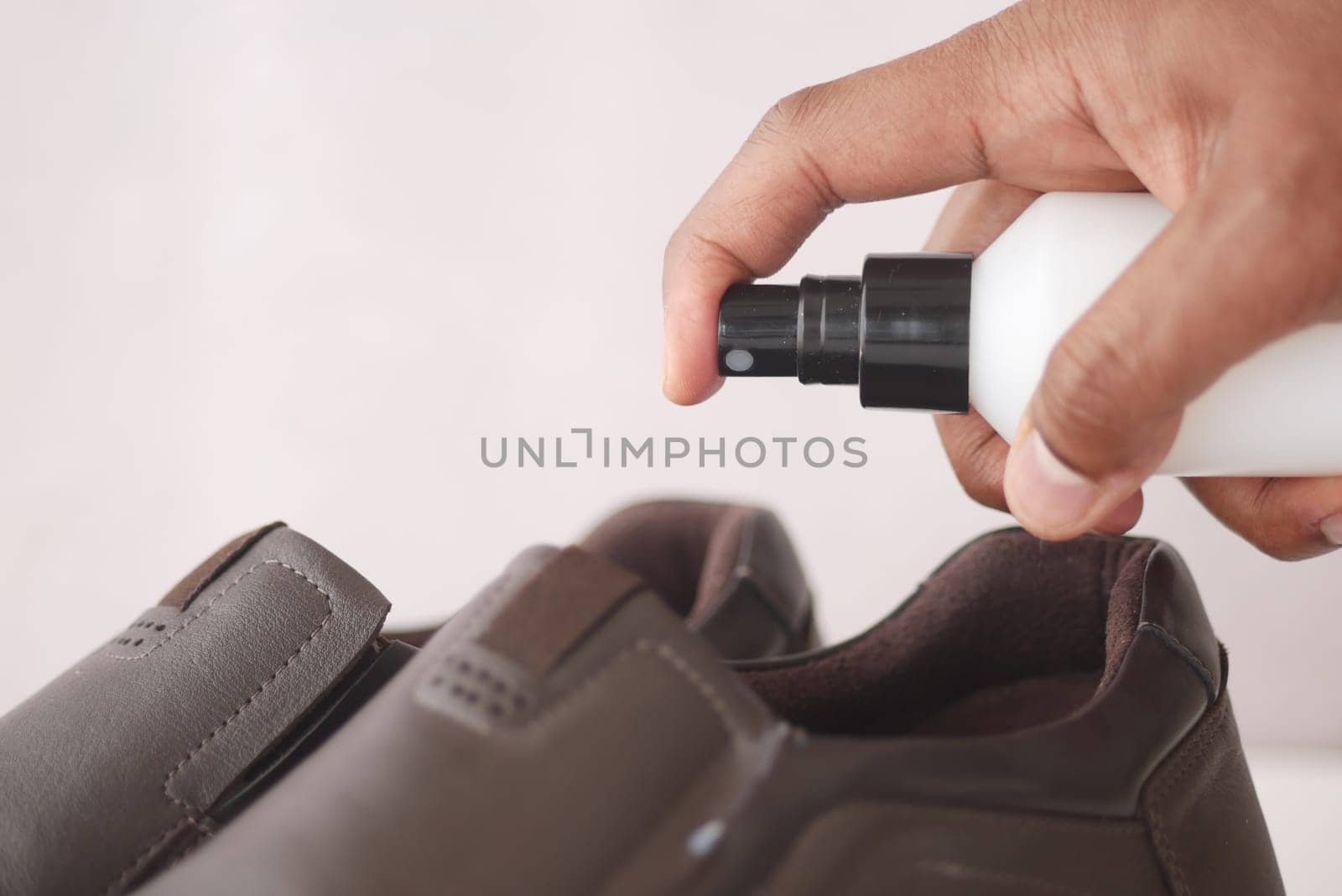 spraying deodorant on sweaty shoes. by towfiq007