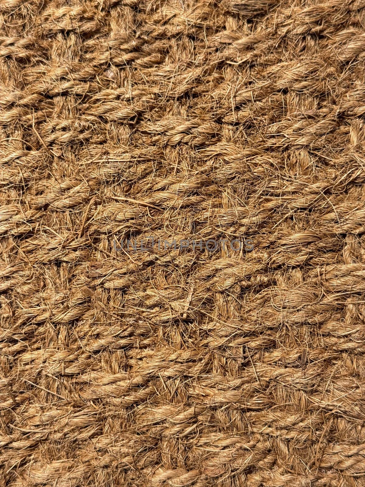 Close up of interwoven natural jute ropes creating textured pattern for rustic backgrounds and sustainable material concept. by Lunnica
