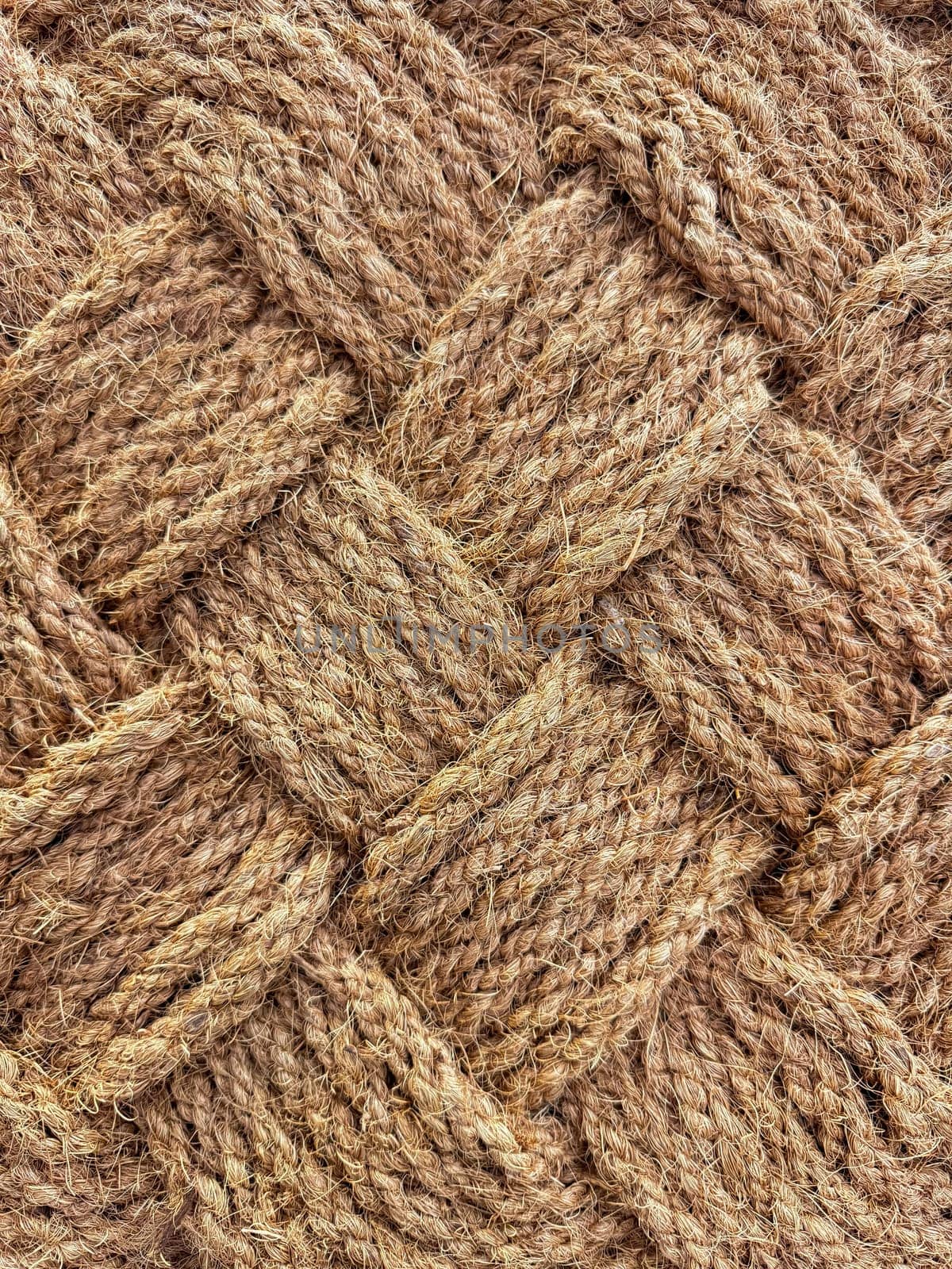 Close up of interwoven natural jute ropes creating textured pattern for rustic backgrounds and sustainable material concept. High quality photo