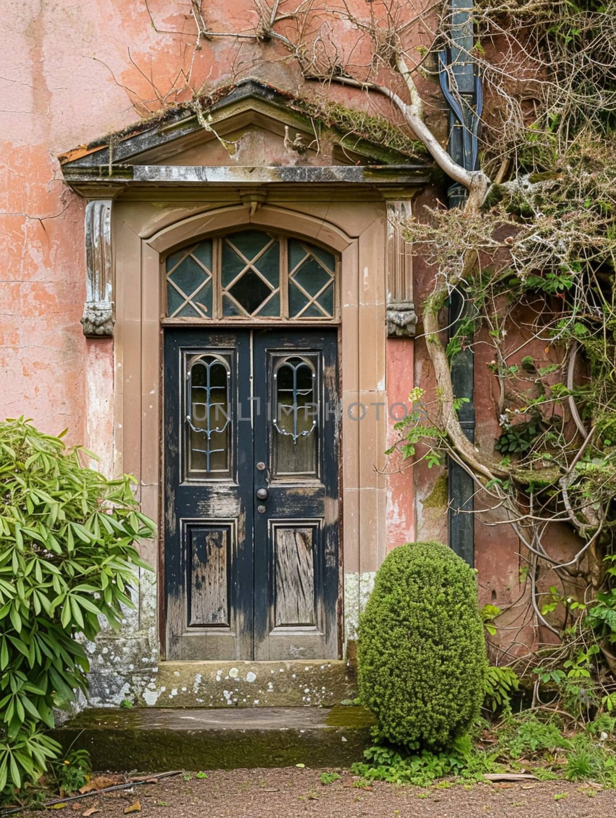 Entrance to a historic manor, framed by antique architectural elements and flanked by potted topiaries, features an aged door by Anneleven