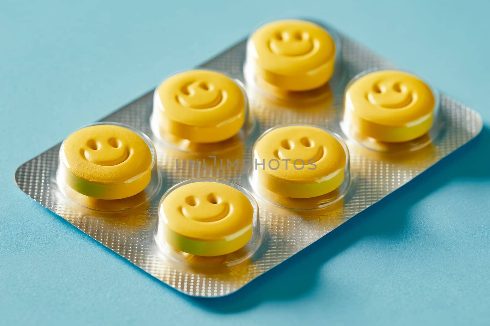 A pack of yellow pills with smiling faces on them. The pills are in a plastic container and are yellow in color. Generative AI