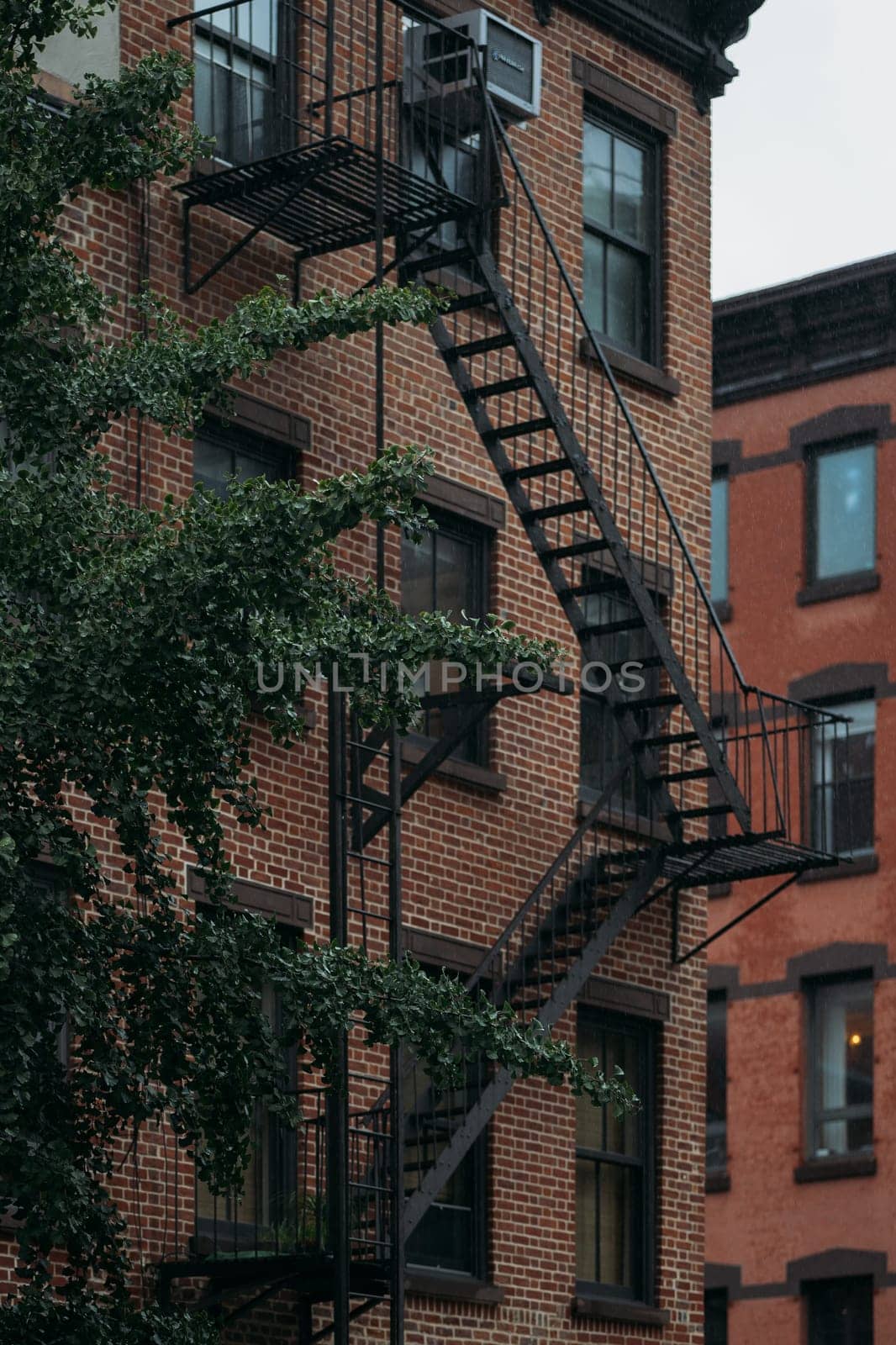 Rain-Soaked Fire Escape on a Brick Building in New York City by apavlin