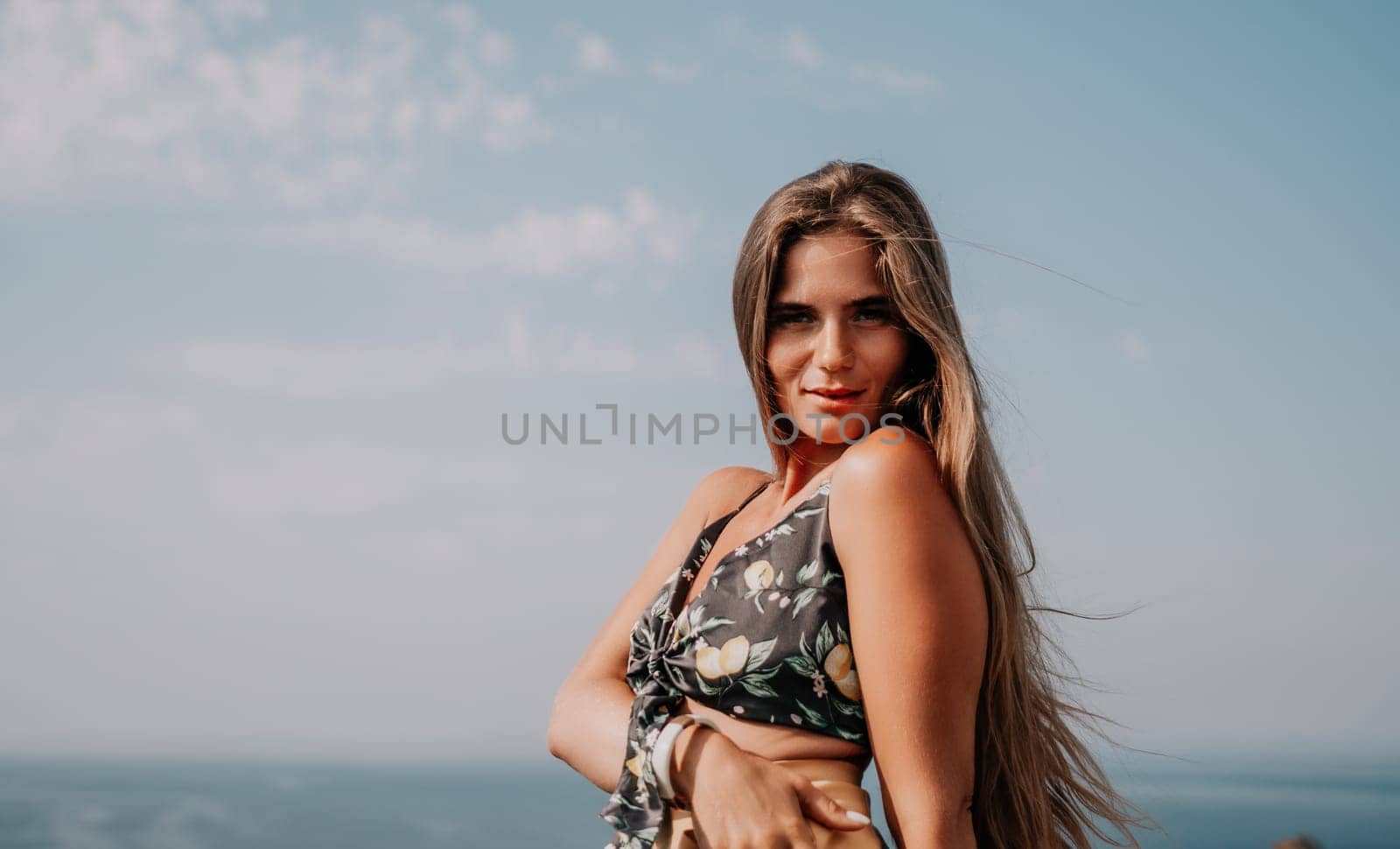 Woman travel sea. Happy tourist taking picture outdoors for memories. Woman traveler looks at the edge of the cliff on the sea bay of mountains, sharing travel adventure journey.