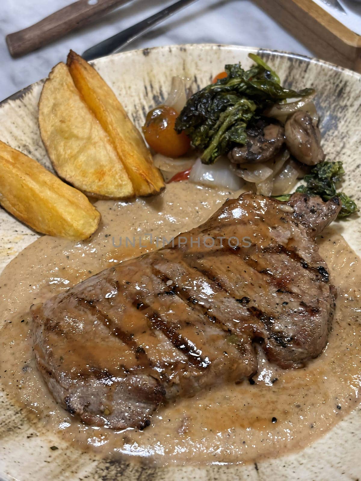 Sirloin steak grilled medium rare served with potatoes and salad with mushroom black pepper sauce by antoksena