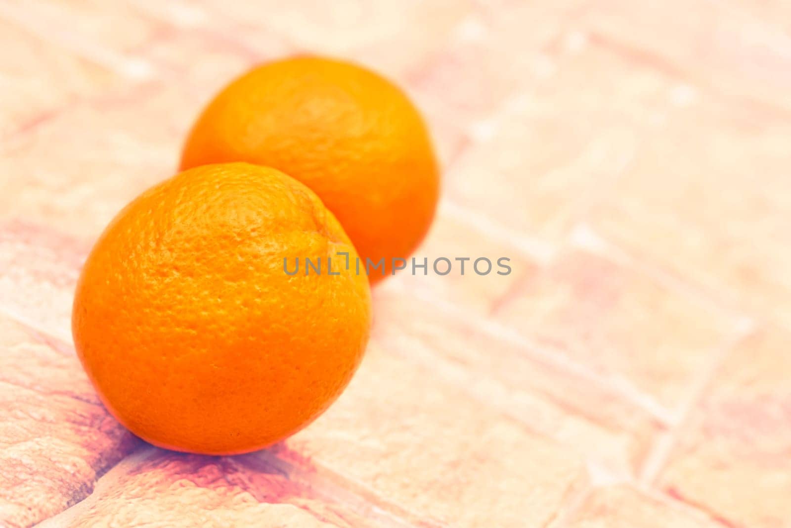 Two ripe sweet juicy oranges on light brown cobblestone by jovani68