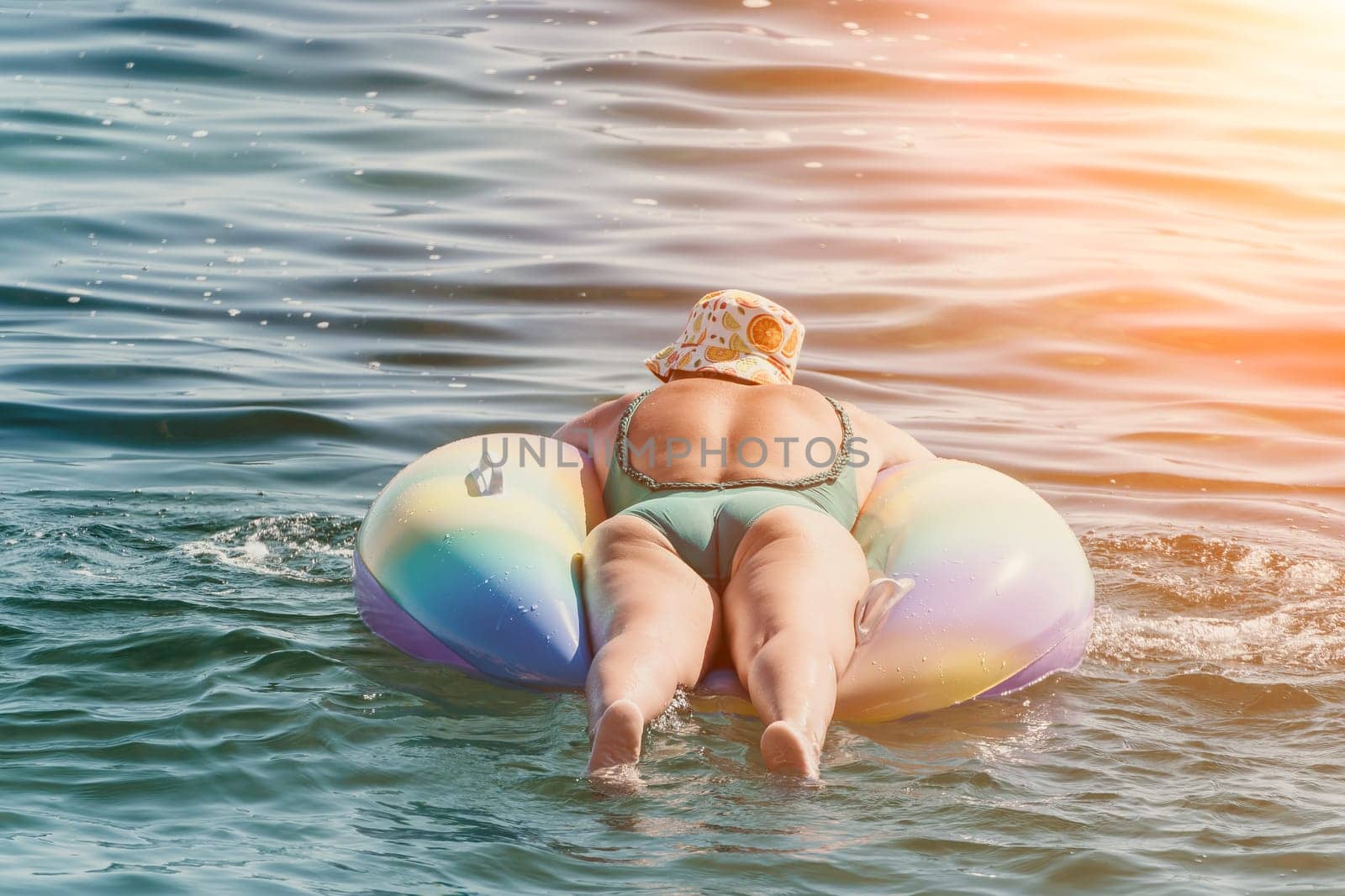 Summer Vacation Woman floats on an inflatable donut mattress, a water toy swim ring. Positive happy woman relaxing and enjoying family summer travel holidays vacation on the sea. Slow motion by panophotograph