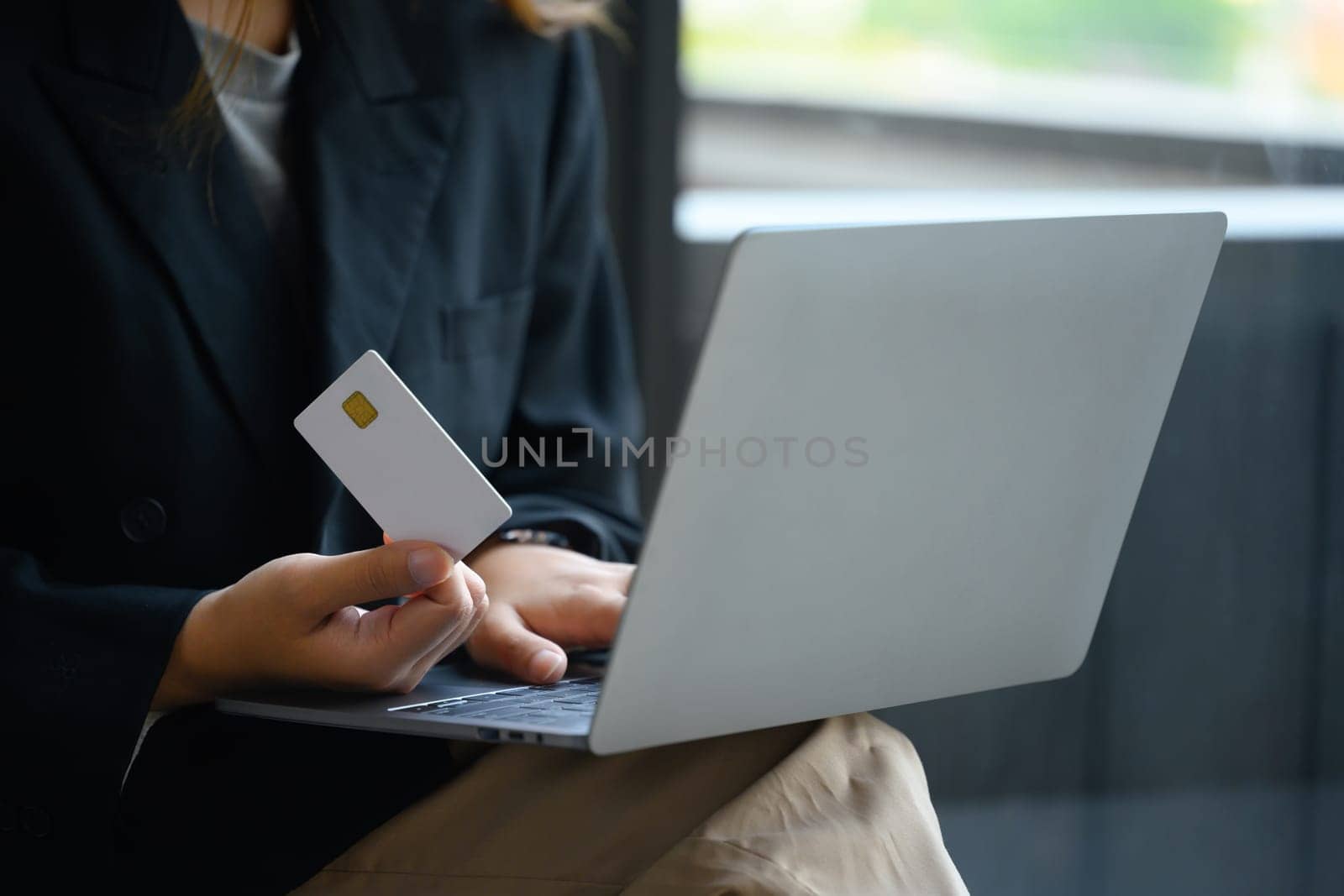 Business woman holding credit card and using laptop making payment or ordering via the internet by prathanchorruangsak